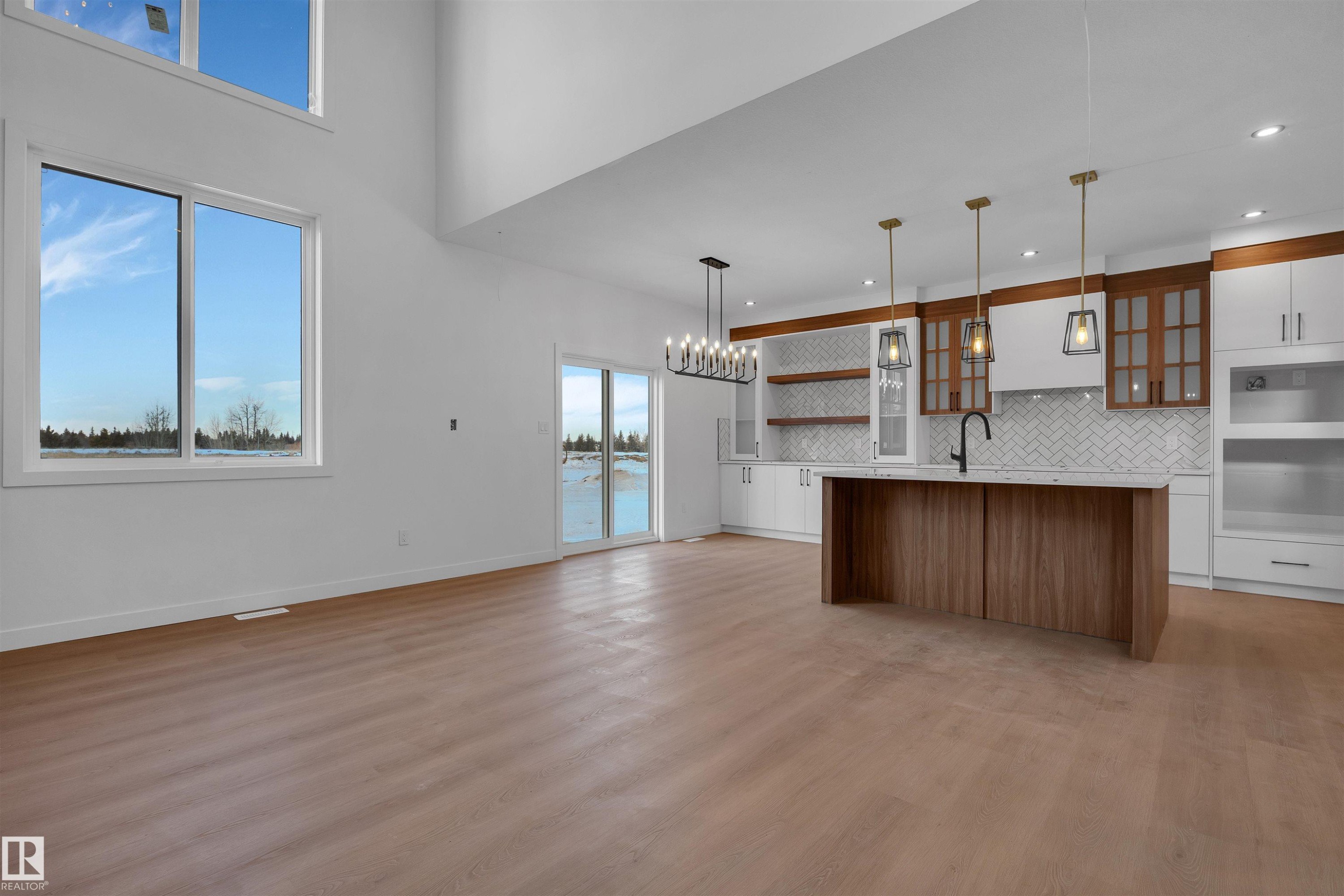 Kitchen featuring brown cabinetry, open shelves, pendant lighting, glass insert cabinets, and white cabinetry - 34 Grayson Green, Stony Plain, AB - Indoor Photo Showing Kitchen