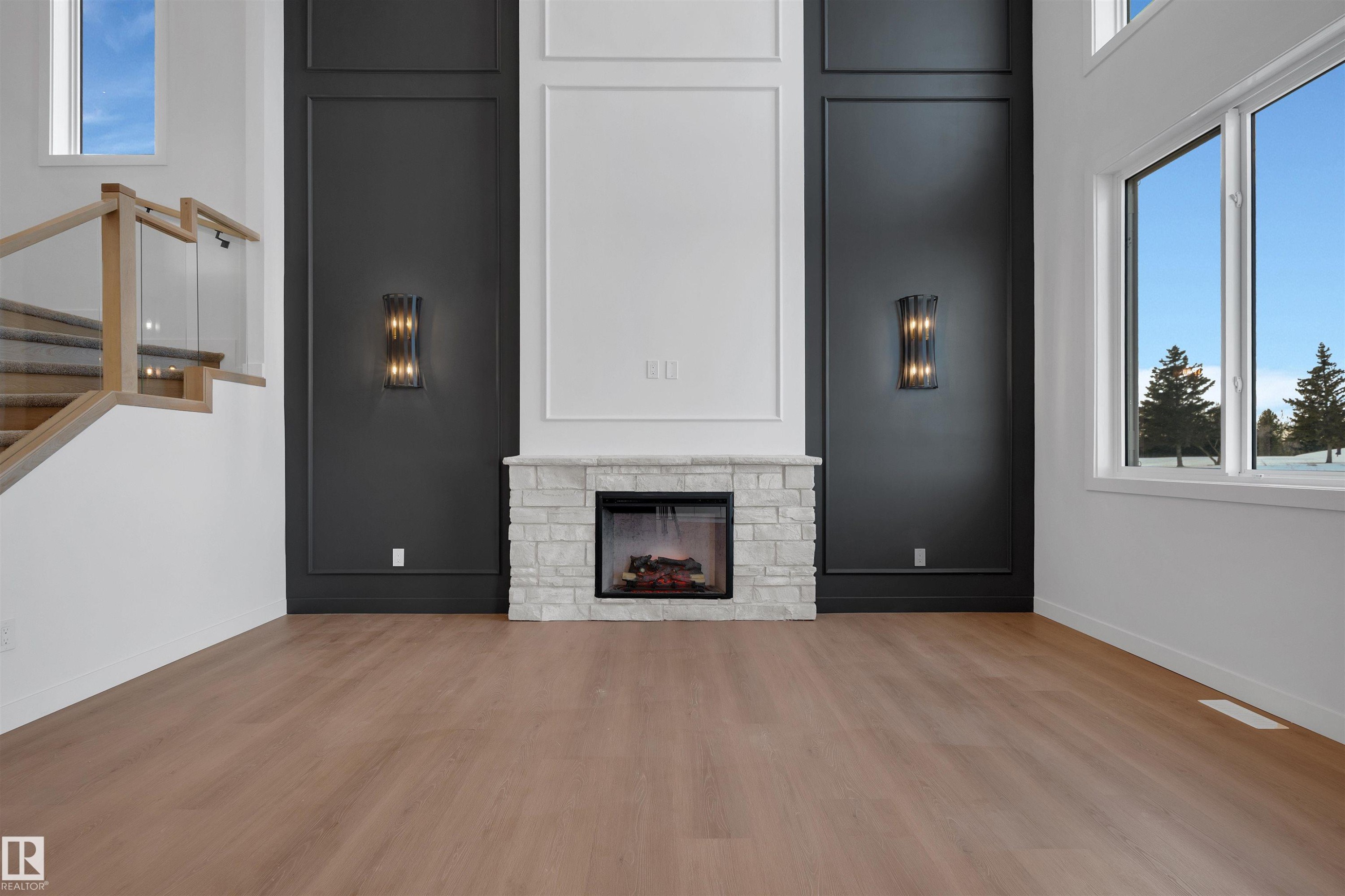 Unfurnished living room featuring stairway, a stone fireplace, and wood finished floors - 34 Grayson Green, Stony Plain, AB - Indoor Photo Showing Other Room With Fireplace