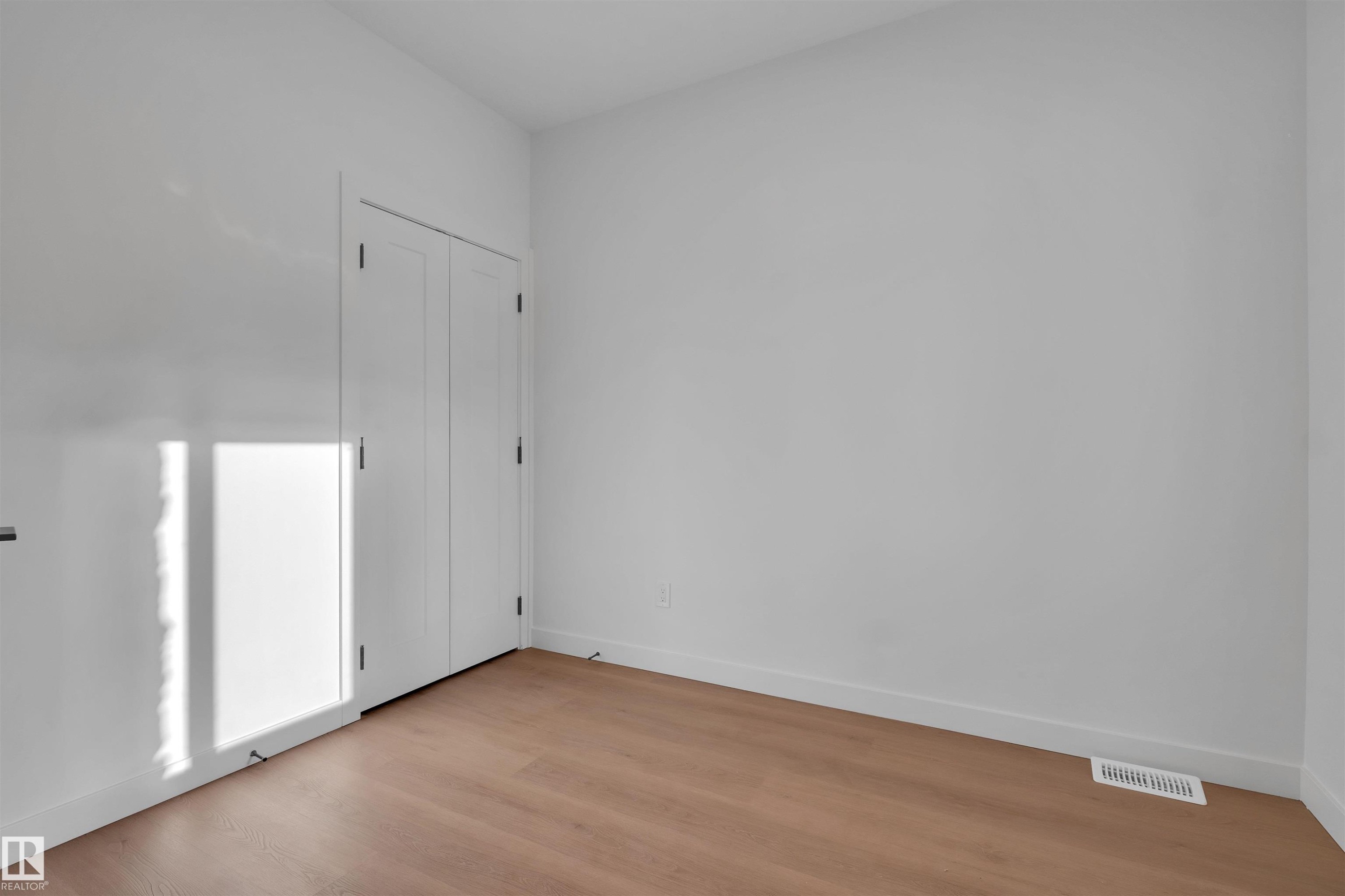 Empty room with baseboards and light wood finished floors - 34 Grayson Green, Stony Plain, AB - Indoor Photo Showing Other Room