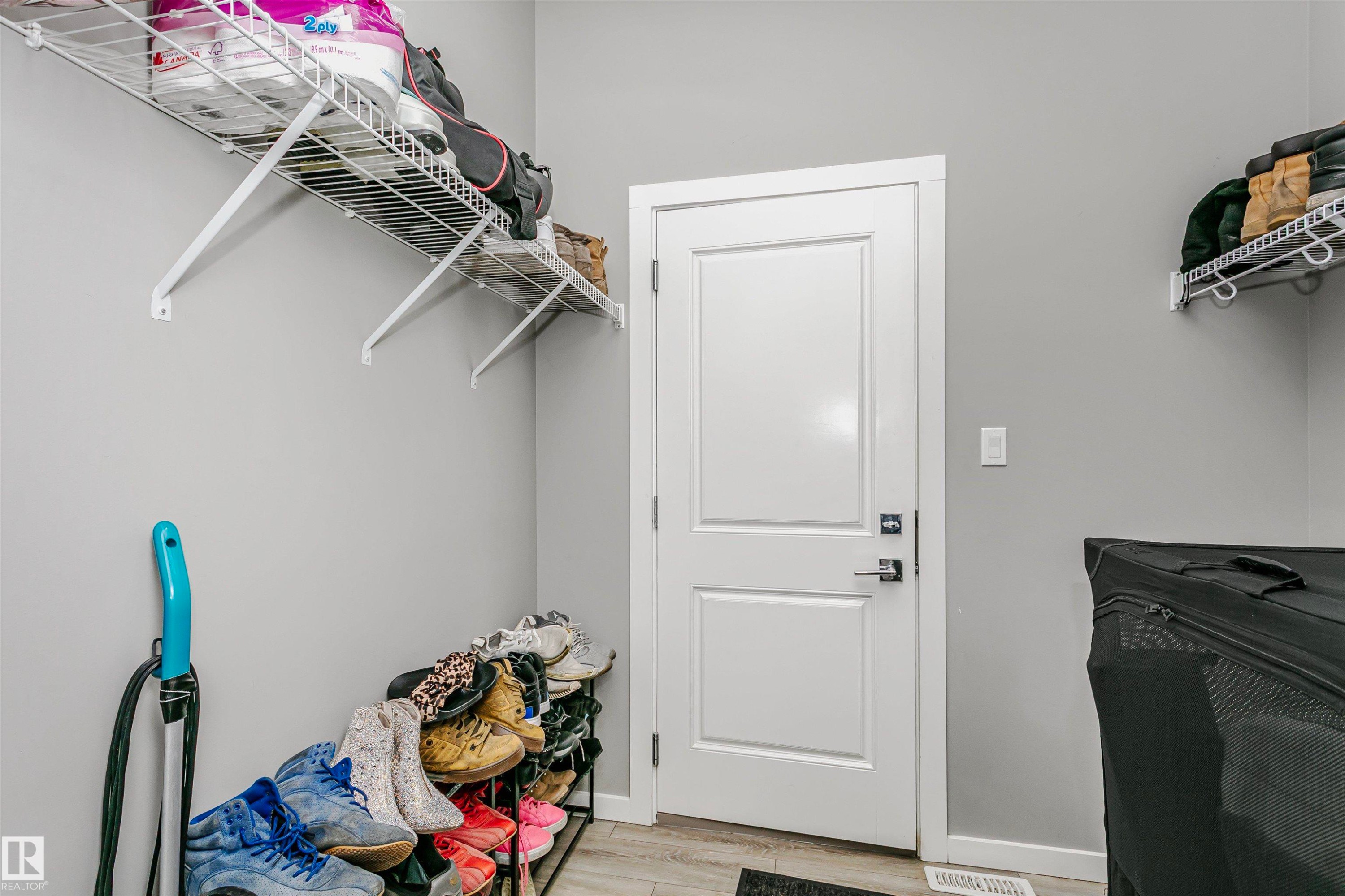 Laundry area with light wood-type flooring and baseboards - 7322 Chivers Crescent, Edmonton, AB - Indoor
