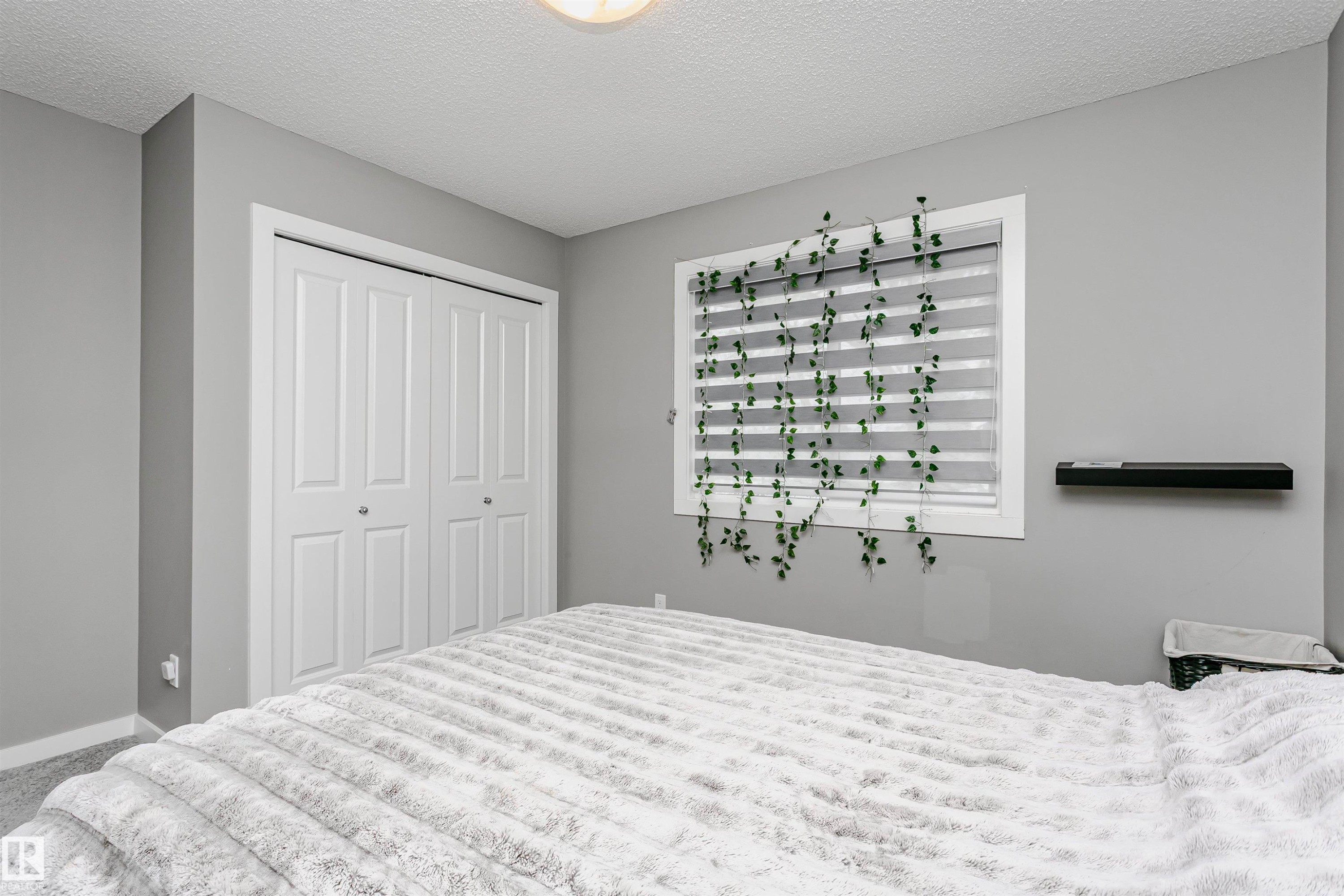 Carpeted bedroom featuring a closet and a textured ceiling - 7322 Chivers Crescent, Edmonton, AB - Indoor Photo Showing Bedroom