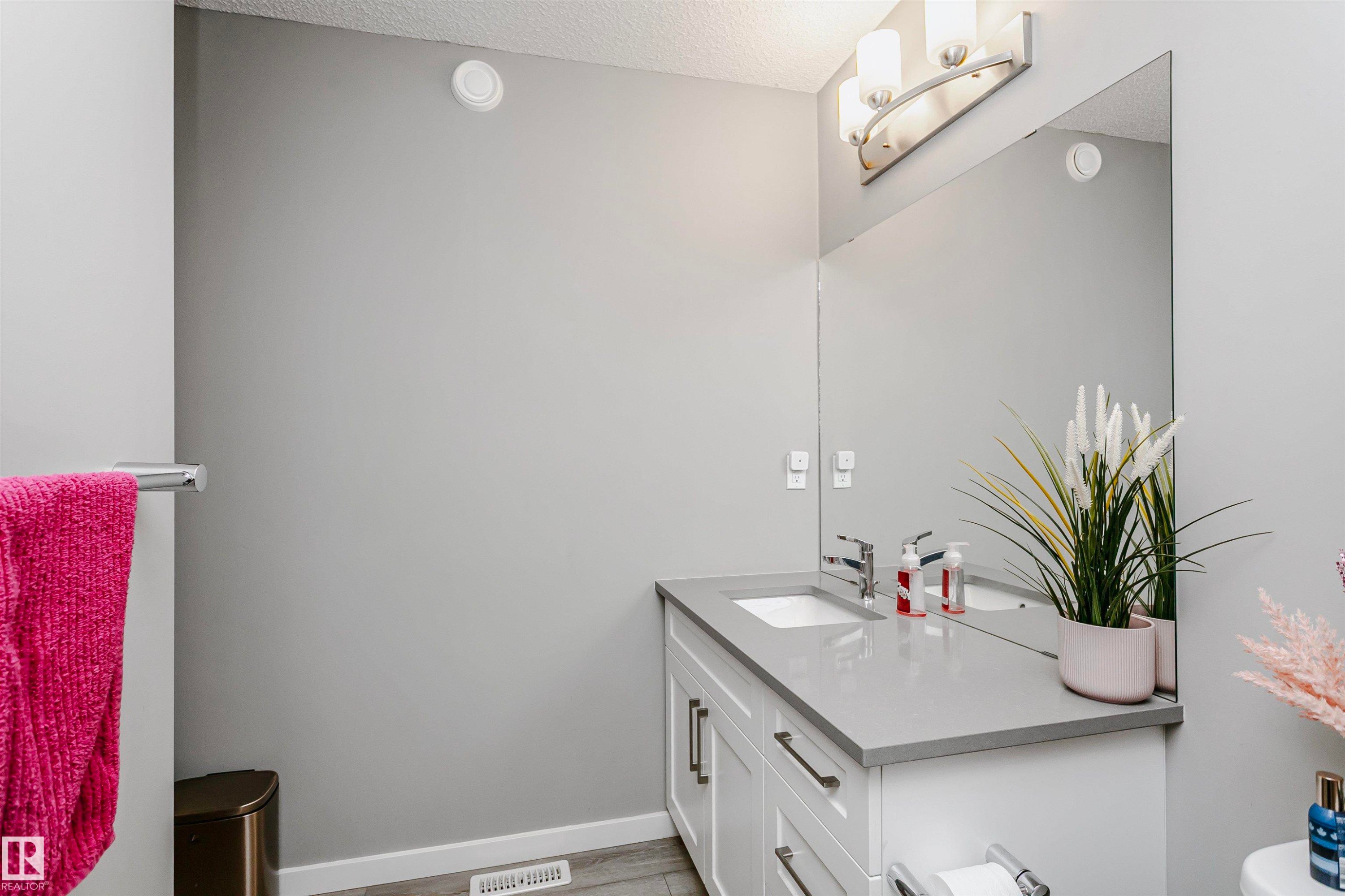 Bathroom featuring vanity, a textured ceiling, and light wood-style flooring - 7322 Chivers Crescent, Edmonton, AB - Indoor Photo Showing Bathroom