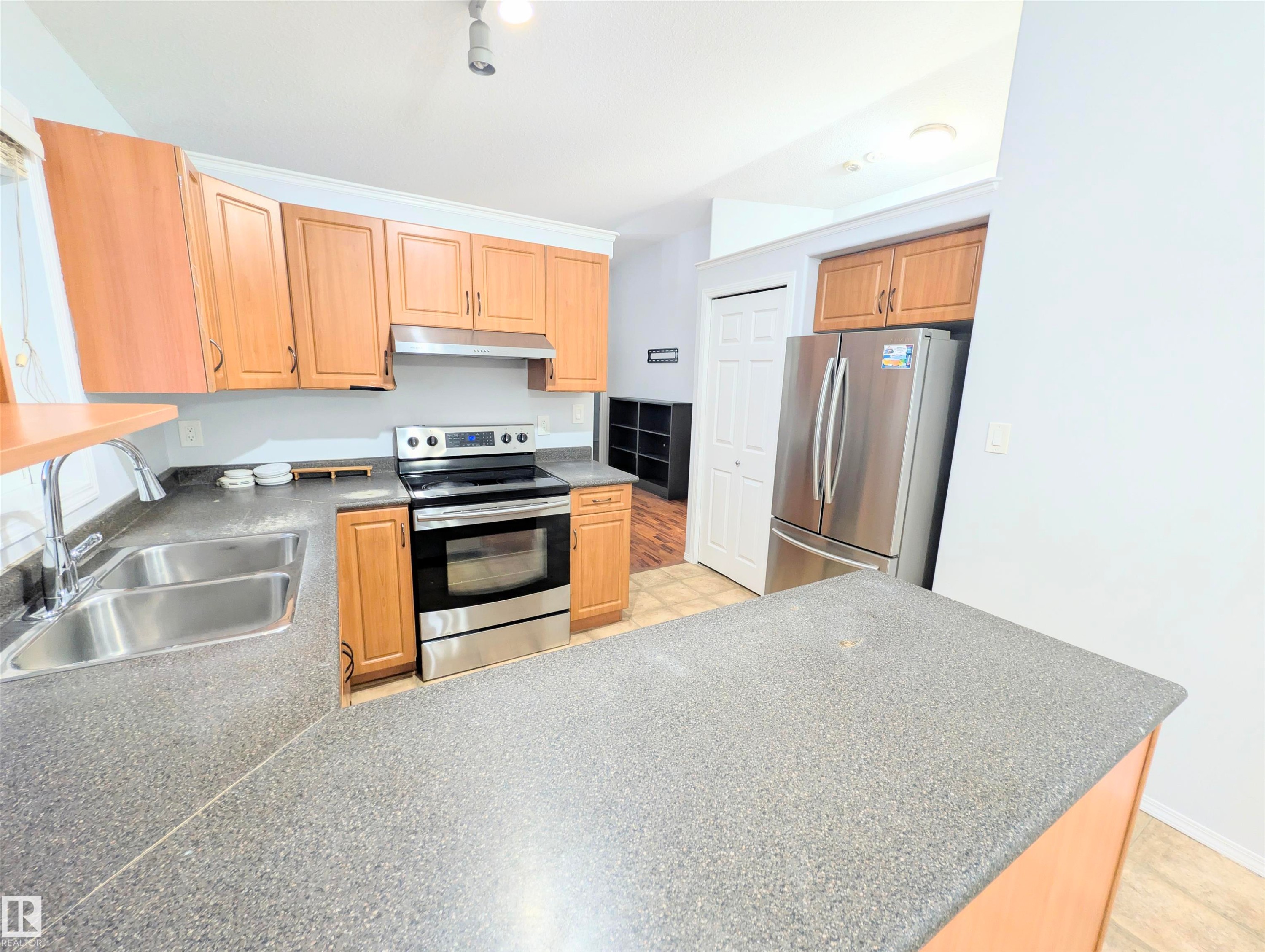 Kitchen with stainless steel appliances and a peninsula - 3307 24 Avenue, Edmonton, AB - Indoor Photo Showing Kitchen With Double Sink