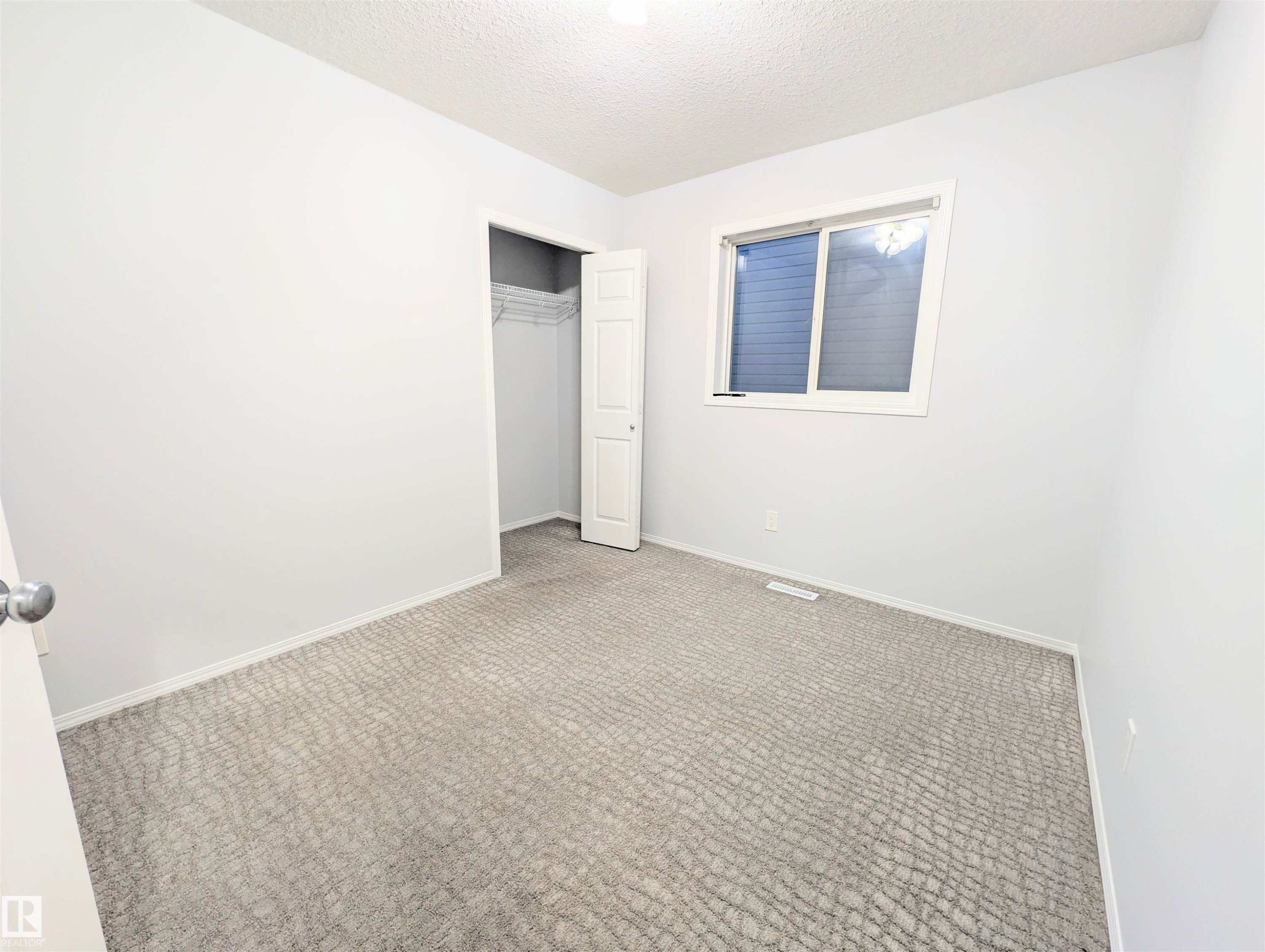 Unfurnished bedroom featuring carpet, a closet, and a textured ceiling - 3307 24 Avenue, Edmonton, AB - Indoor Photo Showing Other Room