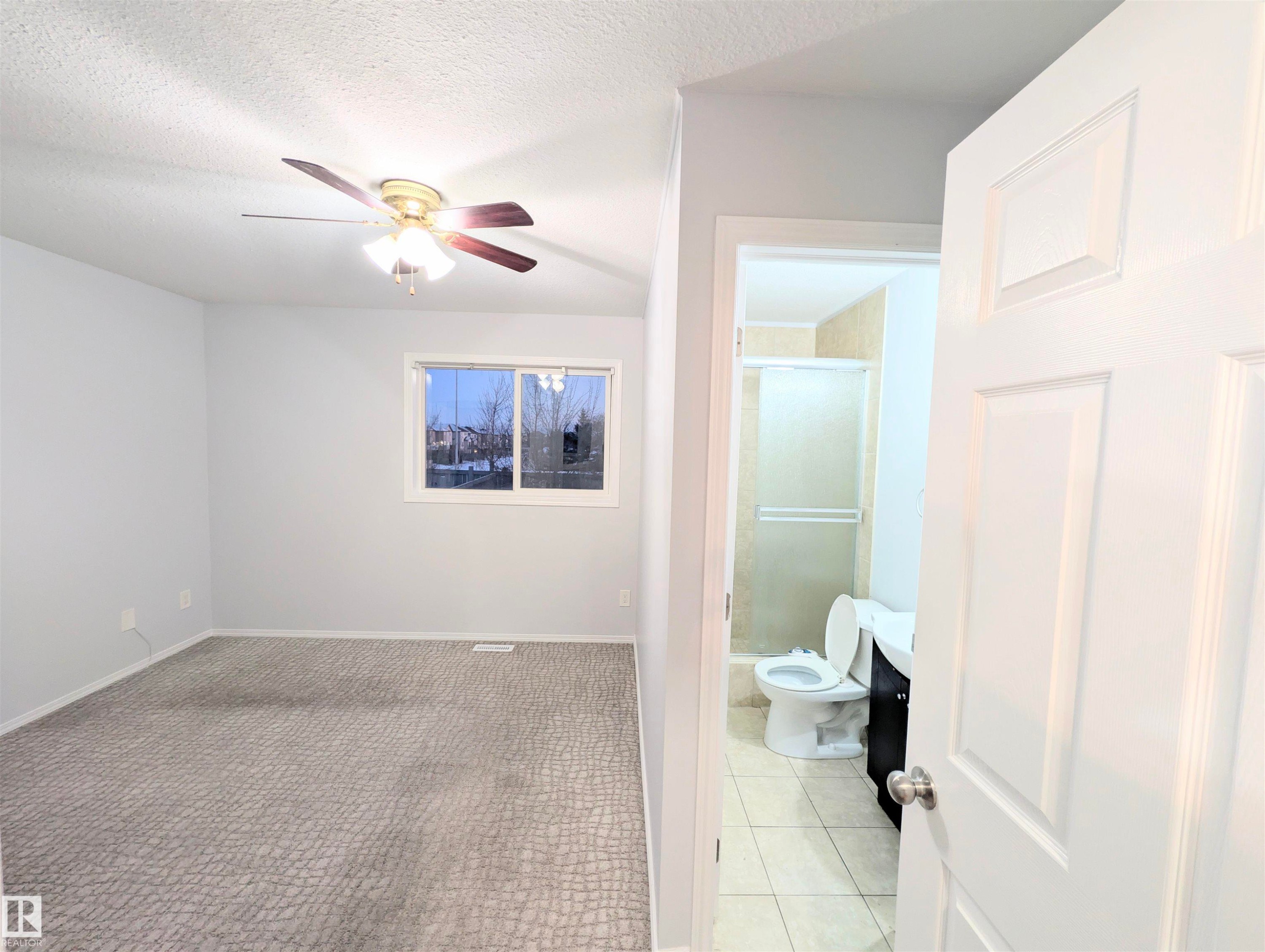 Full bath featuring a stall shower, a ceiling fan, a textured ceiling, and light tile patterned floors - 3307 24 Avenue, Edmonton, AB - Indoor