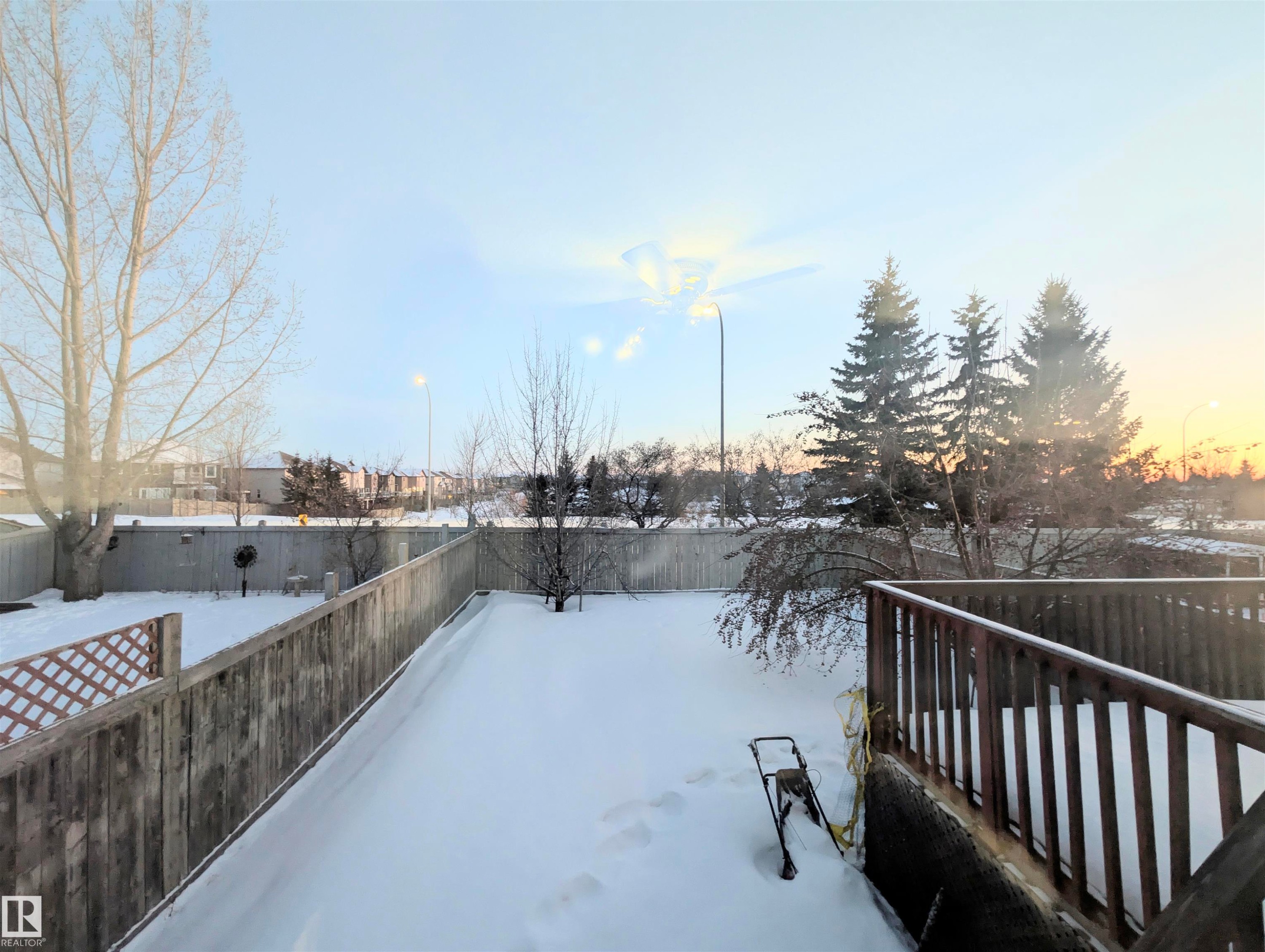 Snowy yard with a fenced backyard and a wooden deck - 3307 24 Avenue, Edmonton, AB - Outdoor