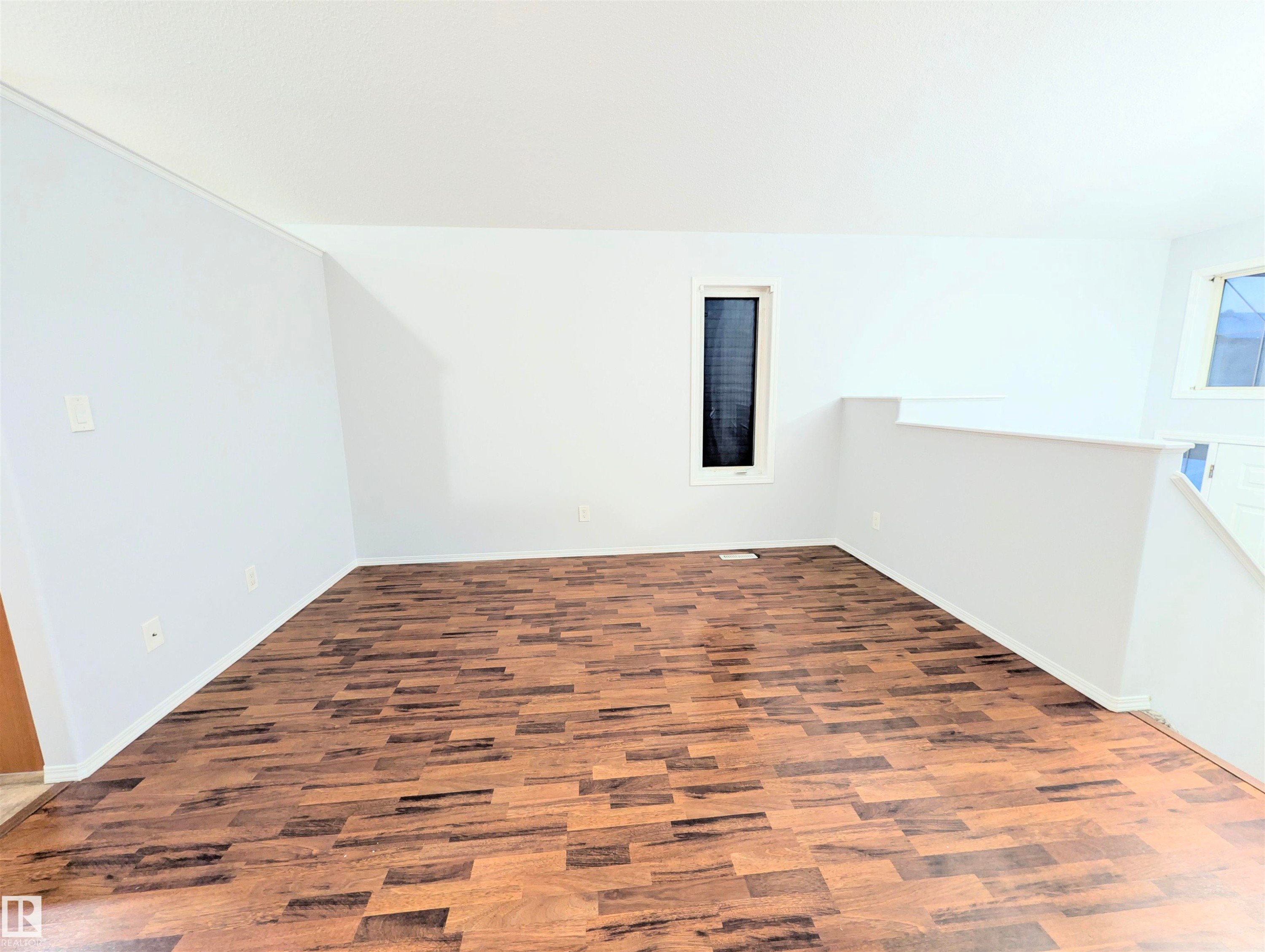 Empty room featuring dark wood-type flooring and baseboards - 3307 24 Avenue, Edmonton, AB - Indoor