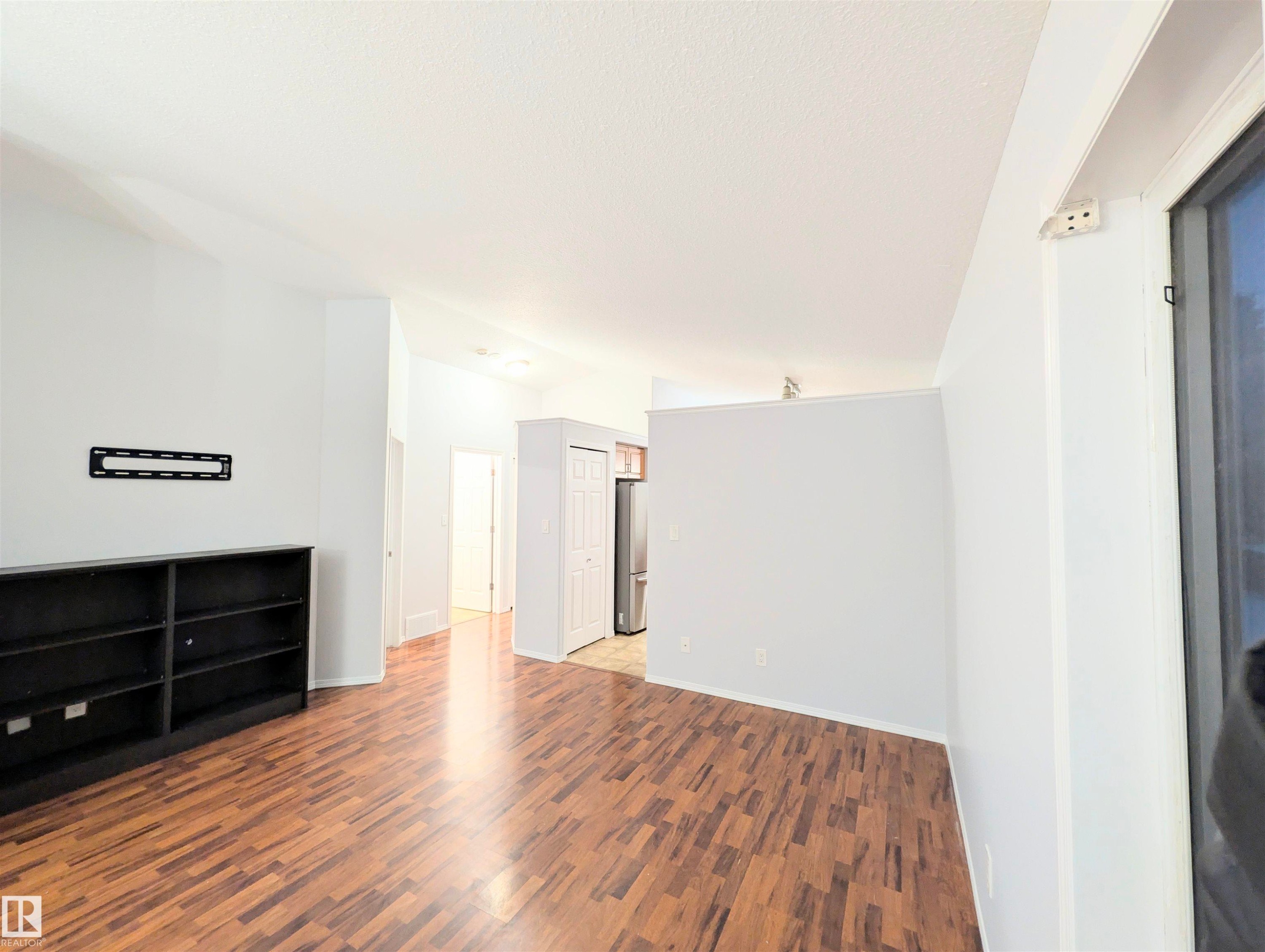 Unfurnished living room with dark wood finished floors and baseboards - 3307 24 Avenue, Edmonton, AB - Indoor Photo Showing Other Room