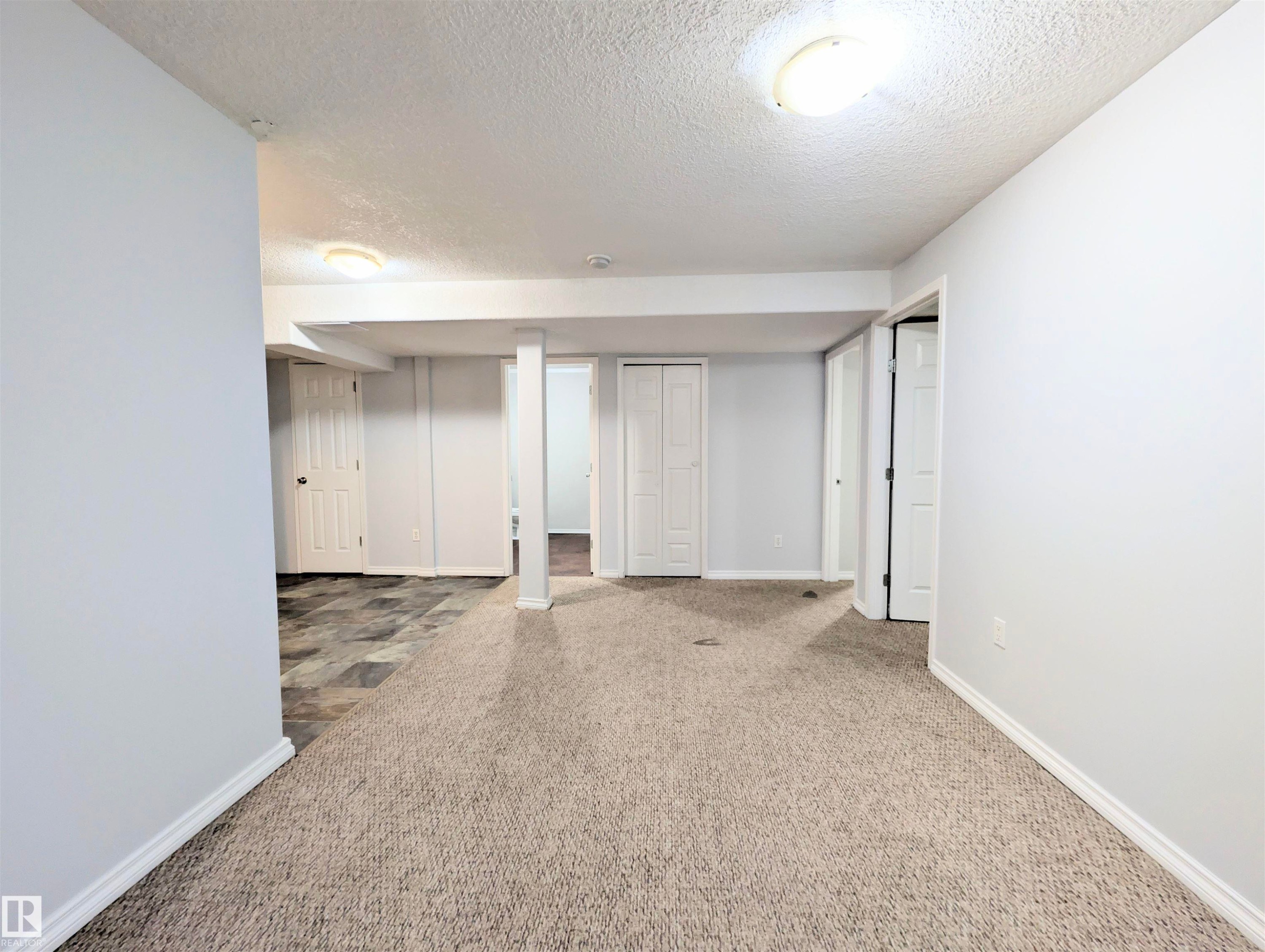 Finished below grade area with a textured ceiling and carpet - 3307 24 Avenue, Edmonton, AB - Indoor Photo Showing Other Room