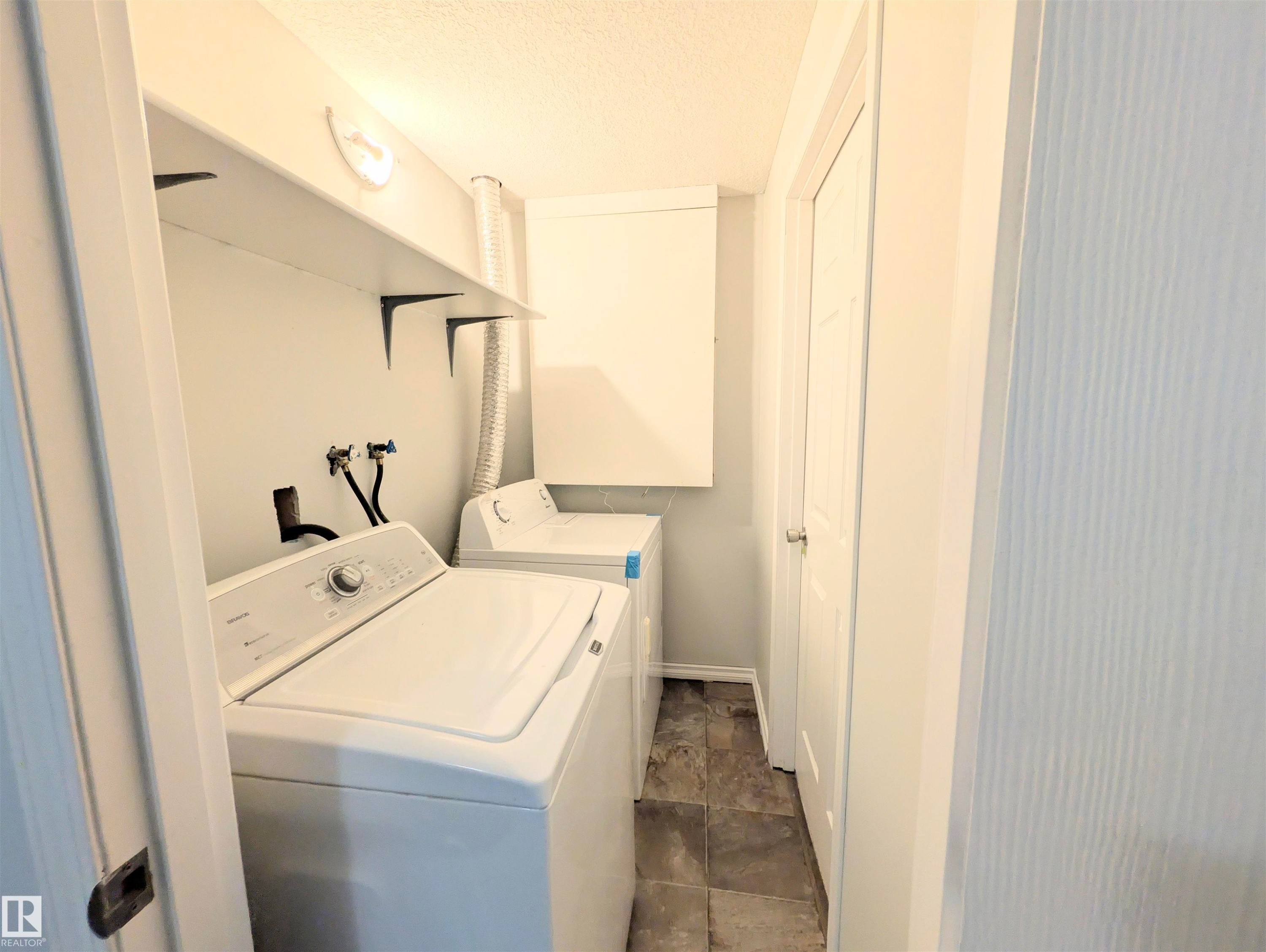 Laundry area with a textured ceiling and separate washer and dryer - 3307 24 Avenue, Edmonton, AB - Indoor Photo Showing Laundry Room