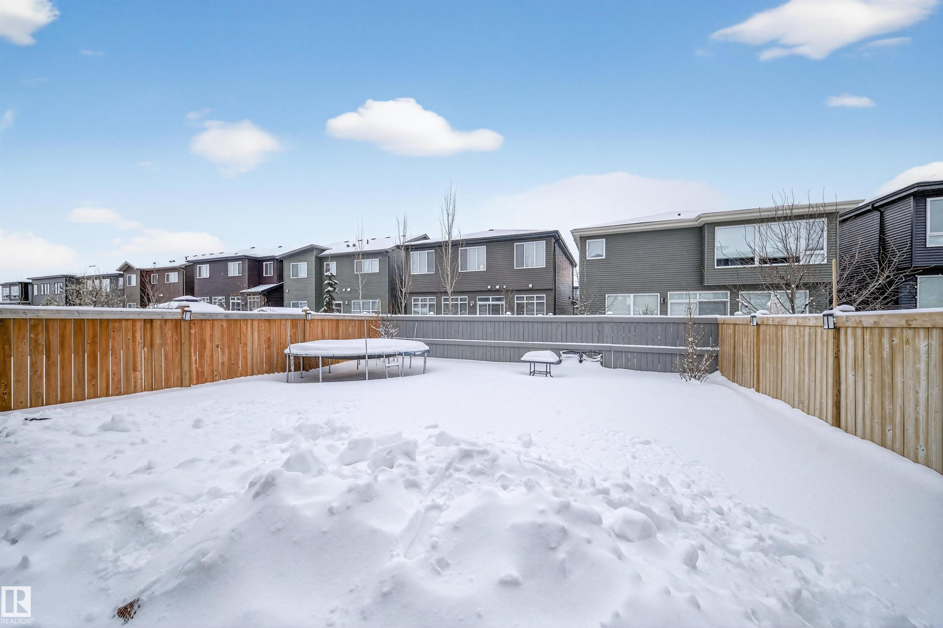 Yard covered in snow featuring a trampoline, a residential view, and a fenced backyard - 6085 King Landing, Edmonton, AB - Outdoor