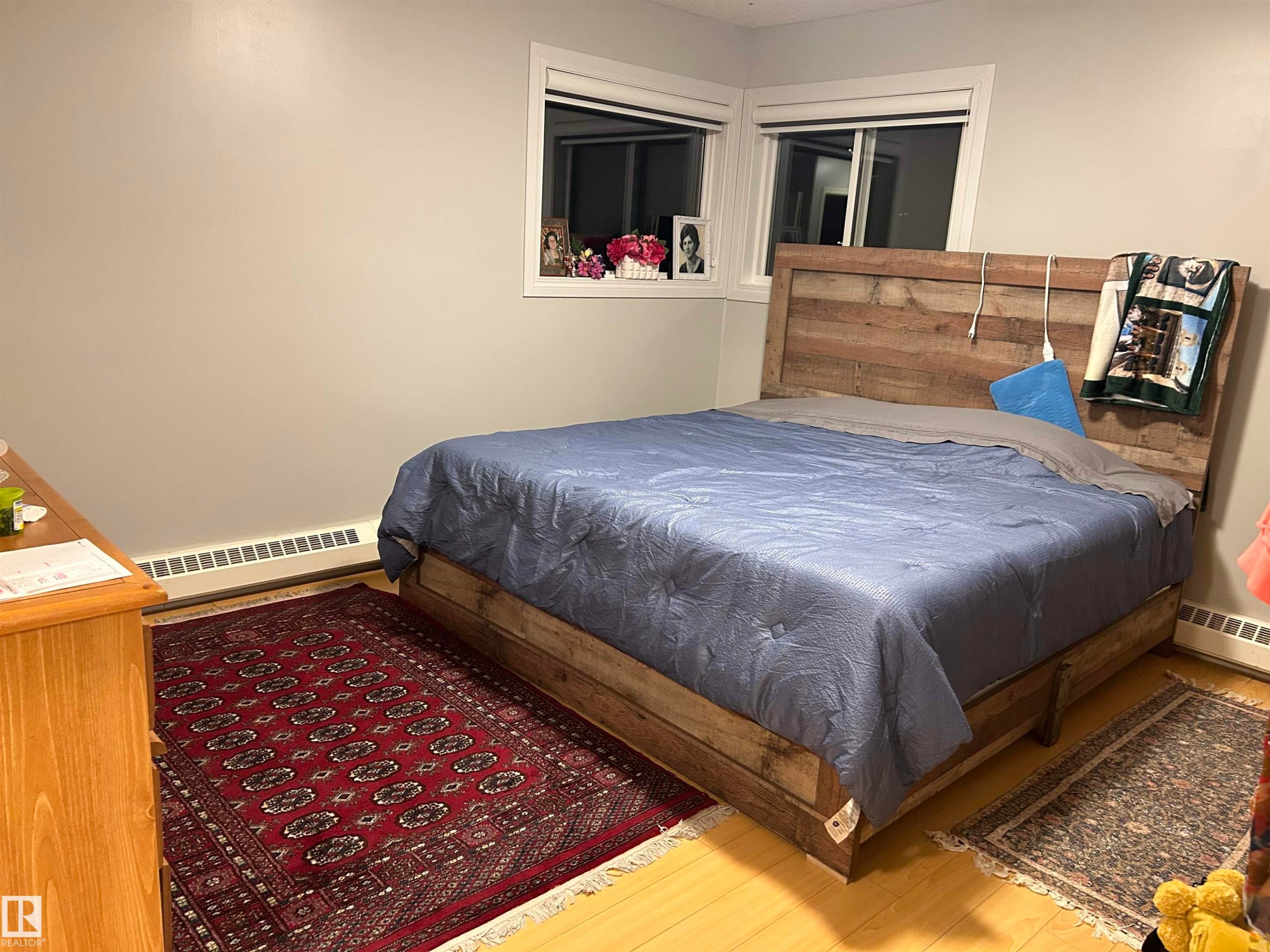 Bedroom with a baseboard heating unit and wood finished floors - 202 18020 95 Avenue, Edmonton, AB - Indoor Photo Showing Bedroom