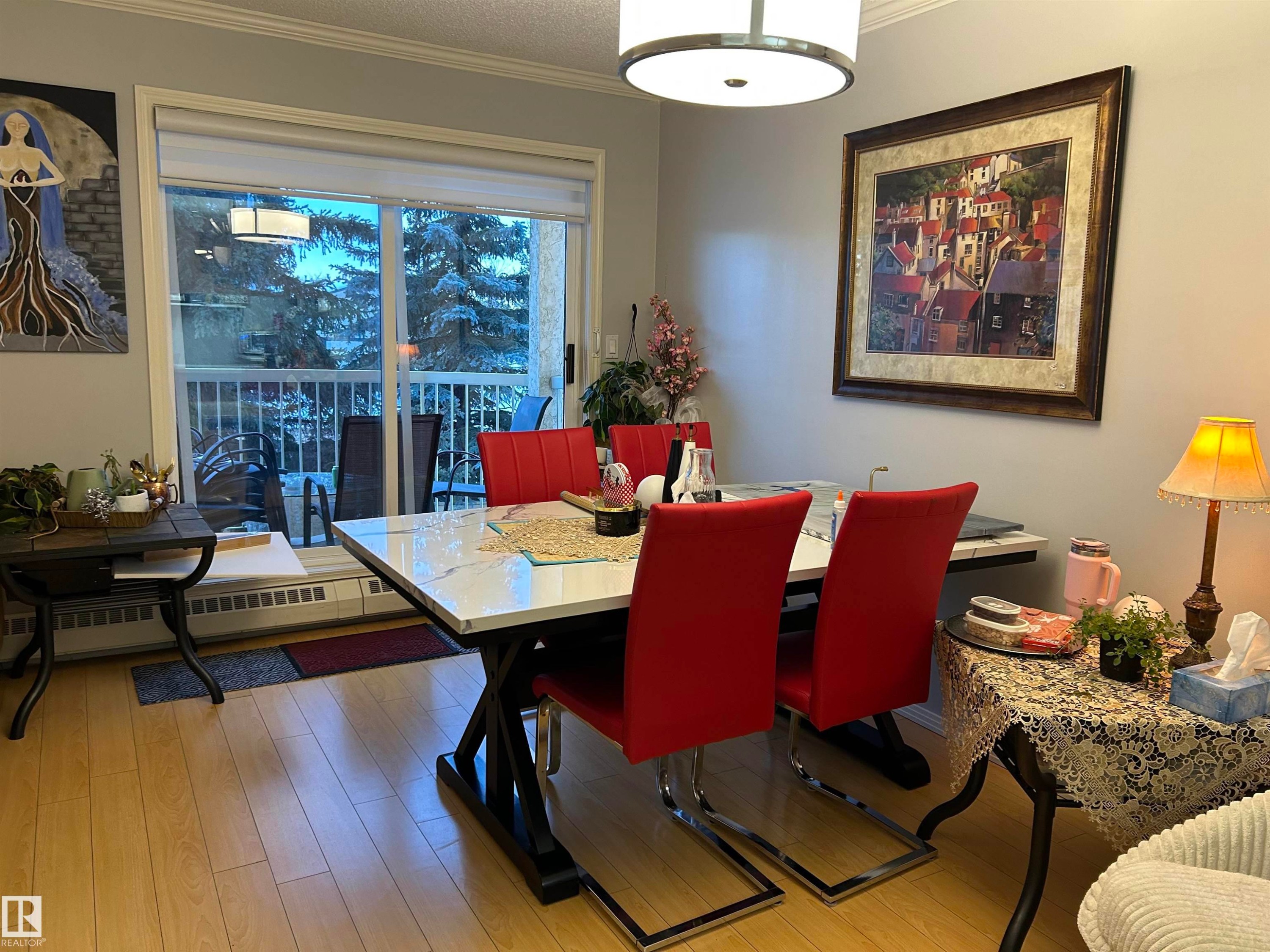 Dining room with a baseboard radiator, wood-type flooring, ornamental molding, and a textured ceiling - 202 18020 95 Avenue, Edmonton, AB - Indoor Photo Showing Dining Room