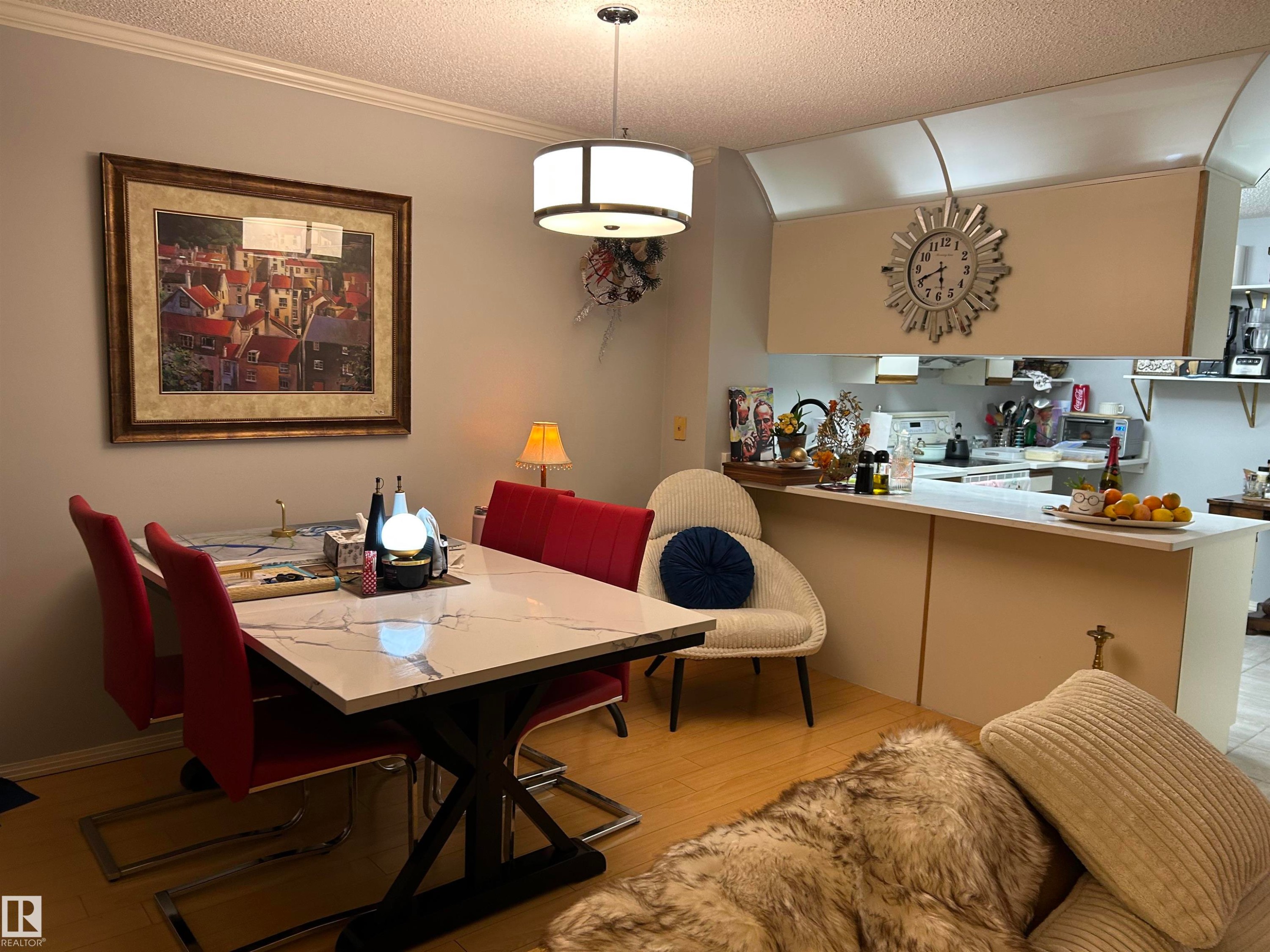 Dining area with a textured ceiling, crown molding, and light wood-style flooring - 202 18020 95 Avenue, Edmonton, AB - Indoor Photo Showing Dining Room