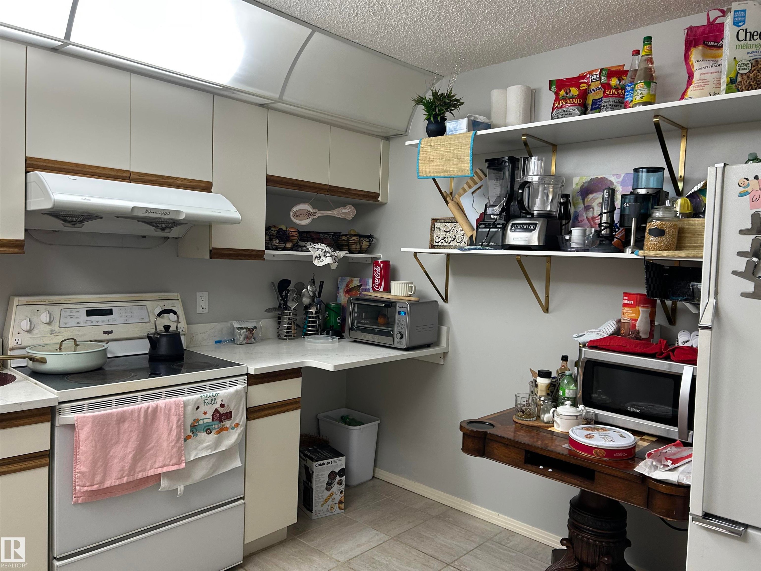 Kitchen with white appliances, a textured ceiling, extractor fan, light countertops, and white cabinets - 202 18020 95 Avenue, Edmonton, AB - Indoor