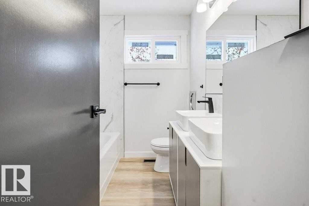 Full bathroom with double vanity and light wood-style flooring - 7016 92A Avenue, Edmonton, AB - Indoor Photo Showing Bathroom