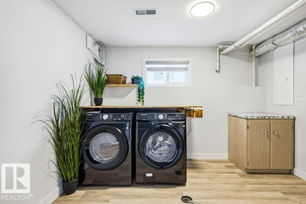 Laundry room with light wood-type flooring and washer and dryer - 7016 92A Avenue, Edmonton, AB - Indoor Photo Showing Laundry Room