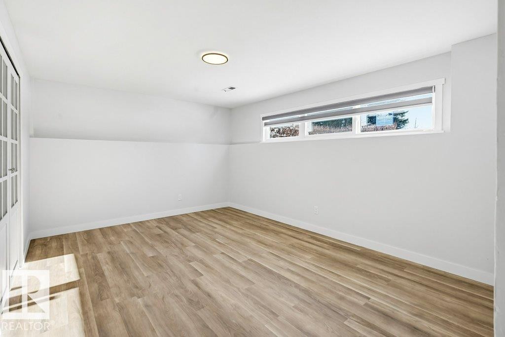 Empty room with light wood-style flooring - 7016 92A Avenue, Edmonton, AB - Indoor Photo Showing Other Room