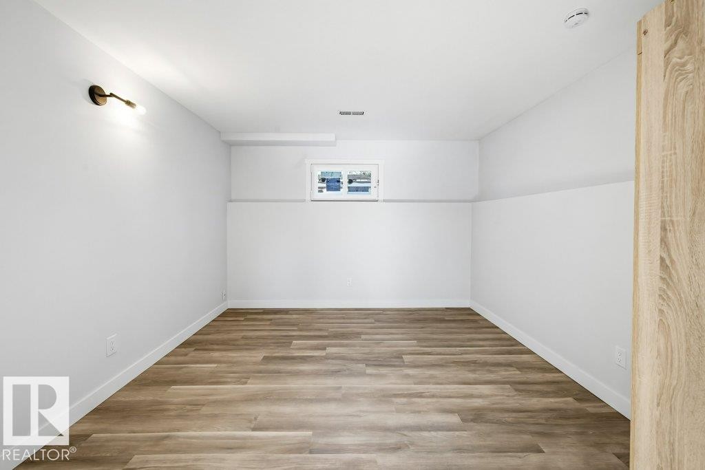 Empty room featuring light wood-style flooring and baseboards - 7016 92A Avenue, Edmonton, AB - Indoor Photo Showing Other Room