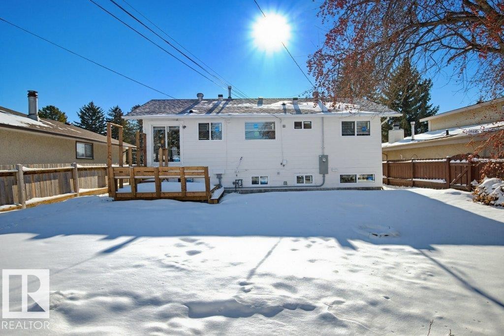 Snow covered back of property featuring a wooden deck - 7016 92A Avenue, Edmonton, AB - Outdoor