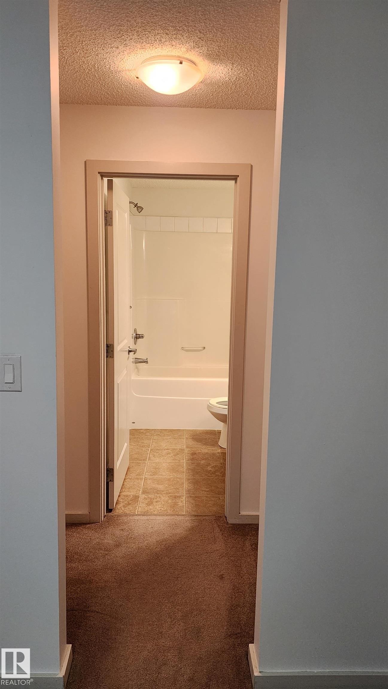 Corridor featuring a textured ceiling and light carpet - 413 5521 7 Avenue, Edmonton, AB - Indoor Photo Showing Bathroom