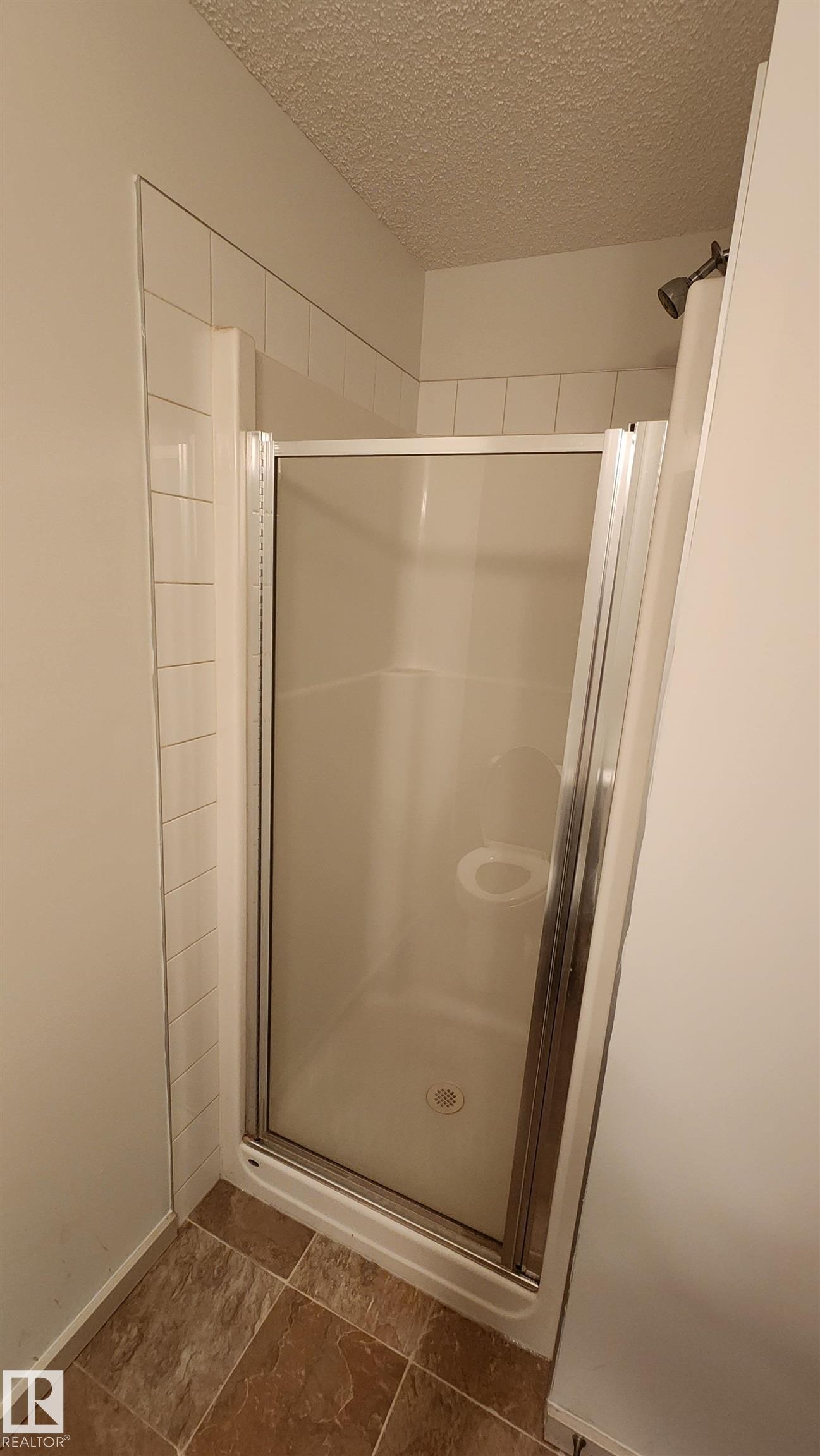 Full bathroom with a stall shower and a textured ceiling - 413 5521 7 Avenue, Edmonton, AB - Indoor Photo Showing Bathroom