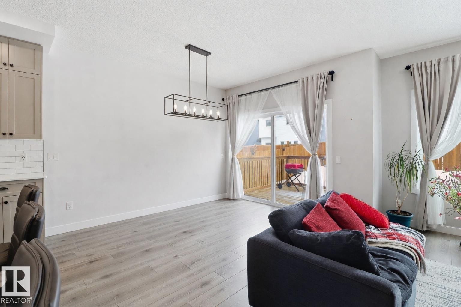 Laundry area featuring light wood-type flooring, a textured ceiling, and a chandelier - 3234 Chernowski Way, Edmonton, AB - Indoor