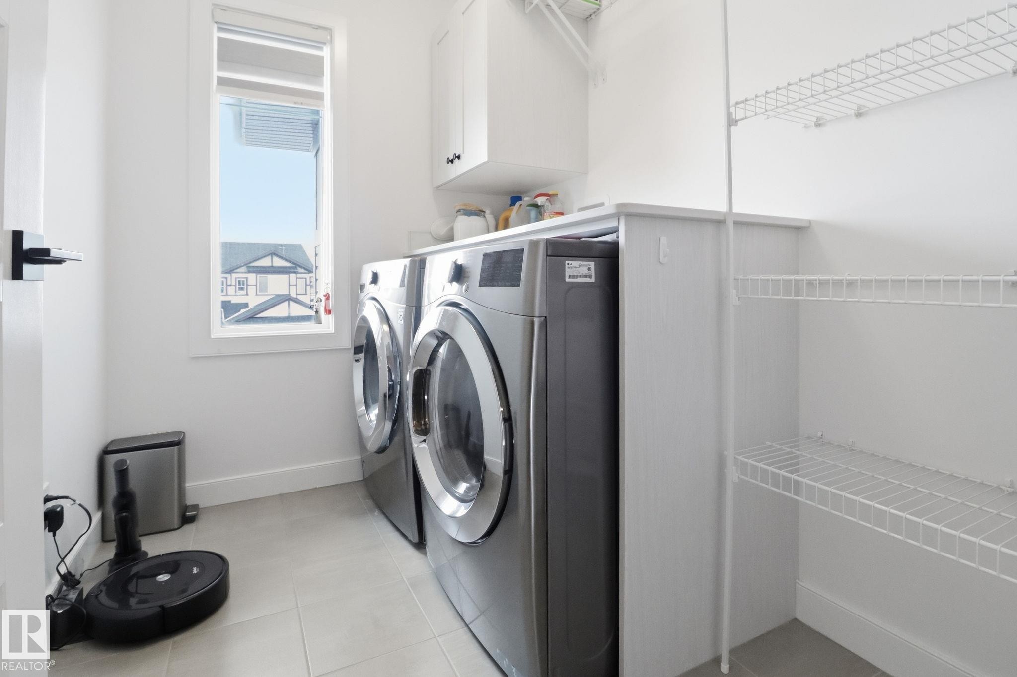 Laundry room featuring cabinet space, light tile patterned flooring, and washer and dryer - 3234 Chernowski Way, Edmonton, AB - Indoor Photo Showing Laundry Room
