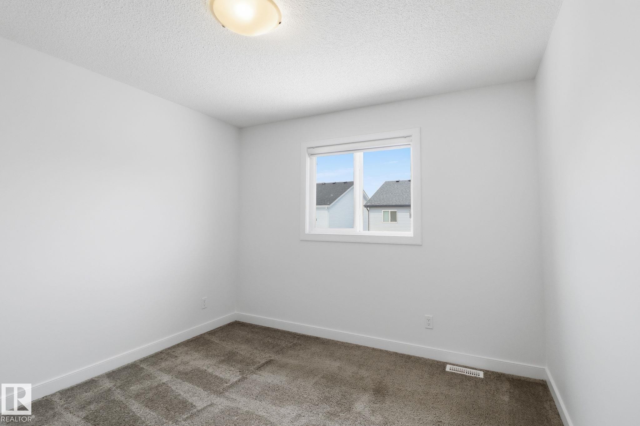Empty room with light carpet and a textured ceiling - 3234 Chernowski Way, Edmonton, AB - Indoor Photo Showing Other Room