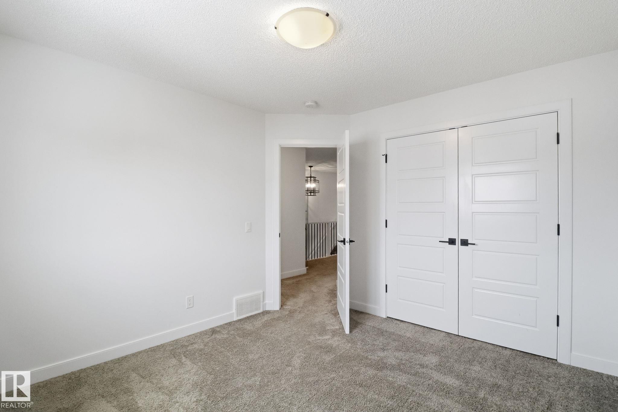 Unfurnished bedroom featuring carpet floors, a closet, and a textured ceiling - 3234 Chernowski Way, Edmonton, AB - Indoor Photo Showing Other Room