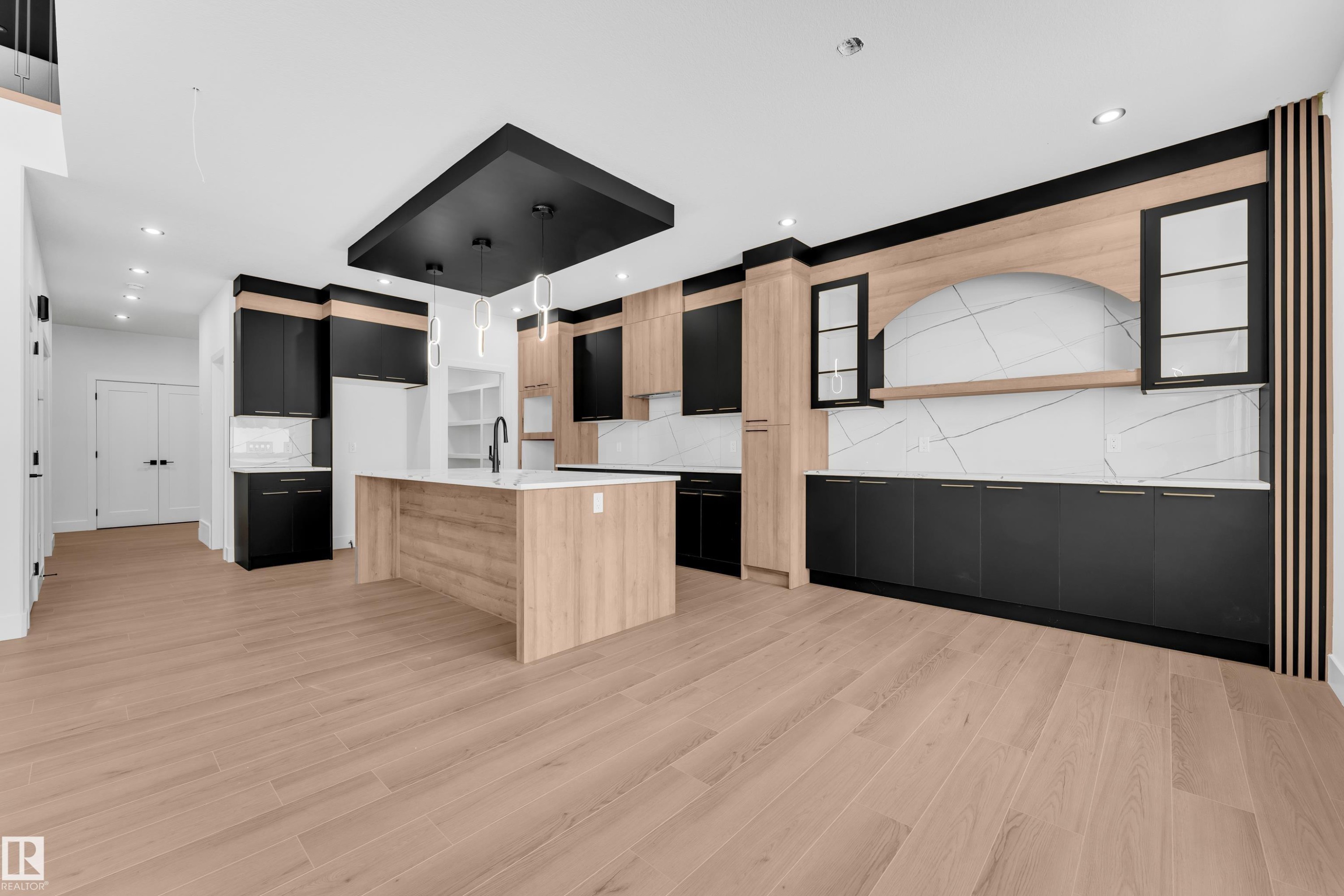 Kitchen with dual tone cabinetry, modern cabinets, a center island with sink, light stone countertops, and light wood-type flooring - 741 Astoria Way, Devon, AB - Indoor Photo Showing Kitchen