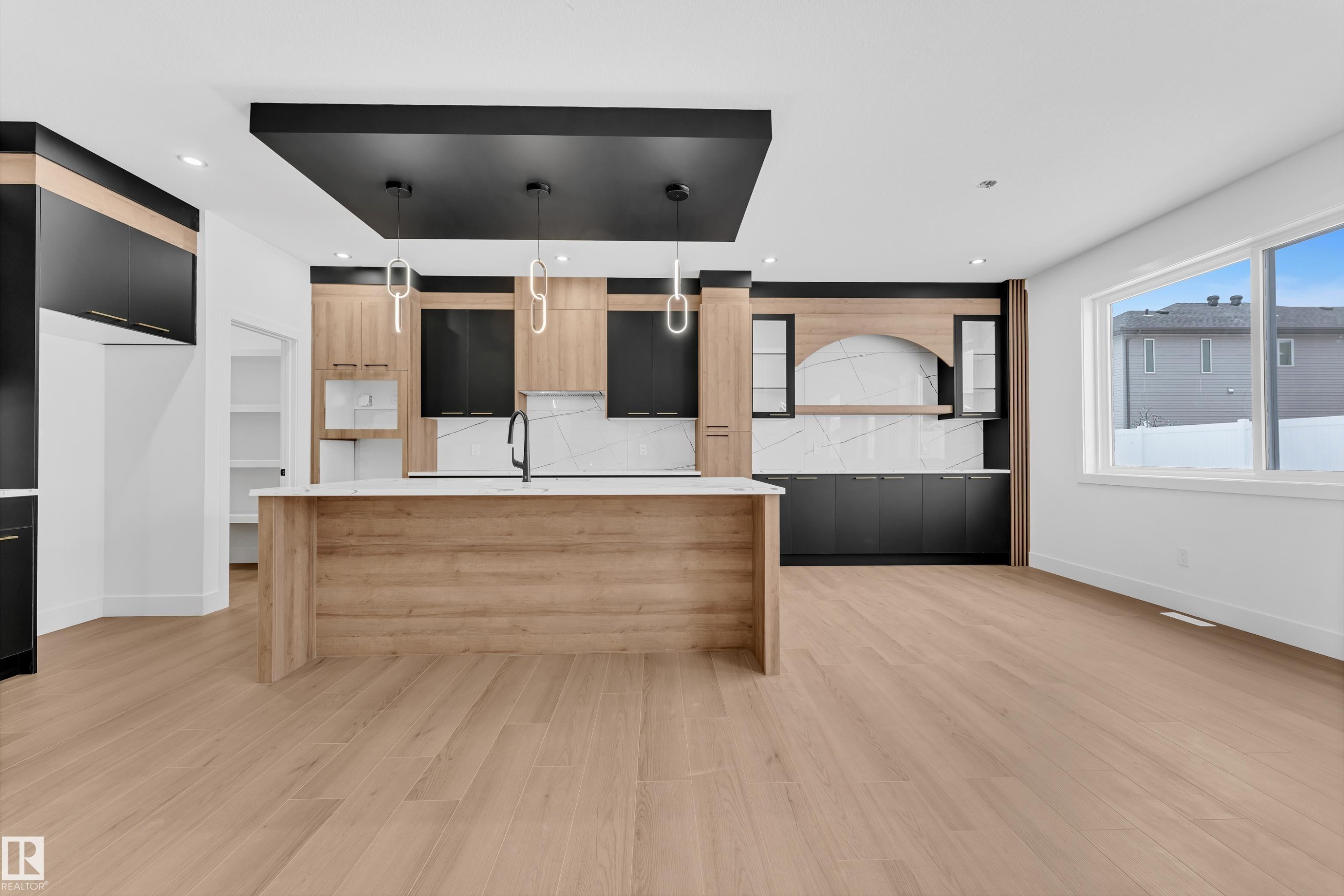 Dual tone kitchen with modern cabinets, dual tone cabinets, light stone countertops, a large island, and pendant lighting - 741 Astoria Way, Devon, AB - Indoor Photo Showing Kitchen