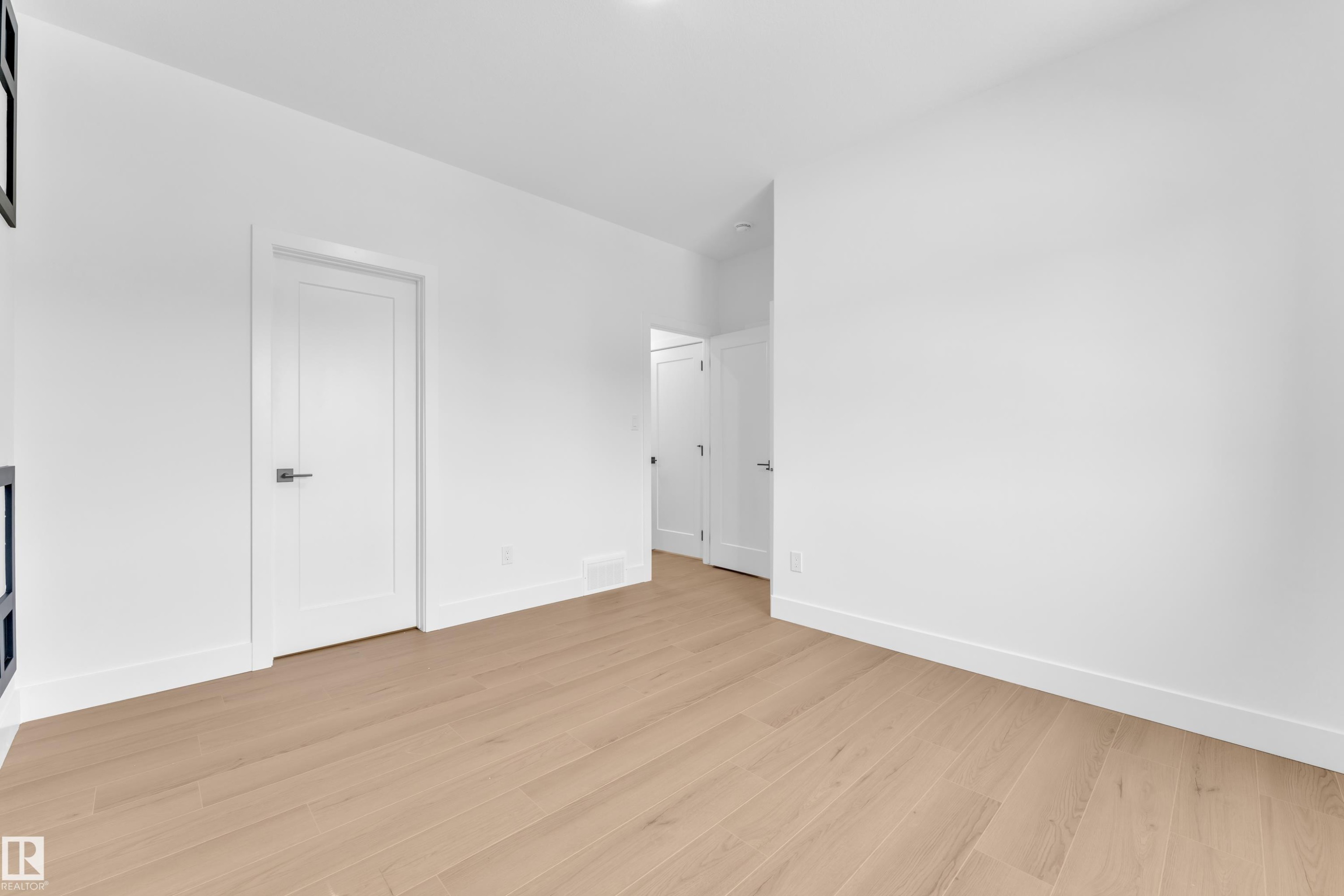 Unfurnished bedroom featuring baseboards and light wood-style flooring - 741 Astoria Way, Devon, AB - Indoor Photo Showing Other Room