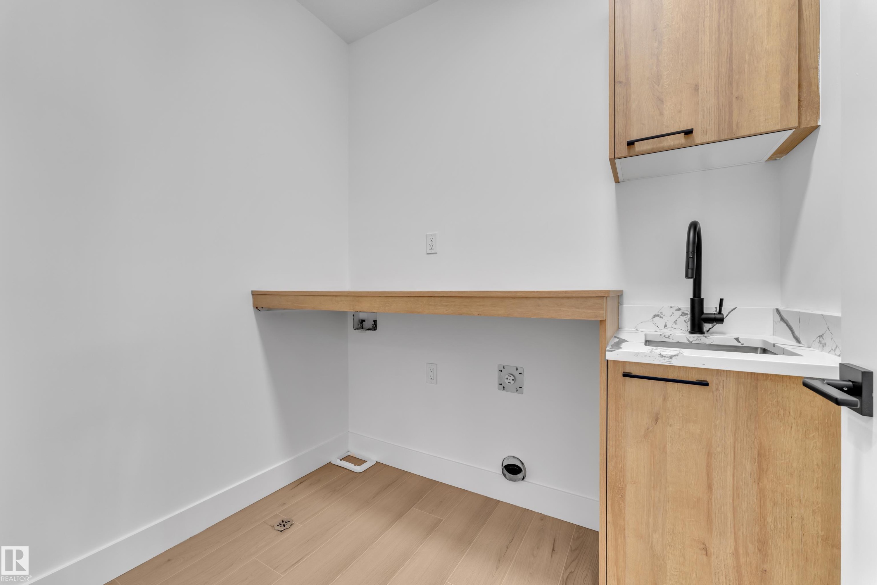 Laundry area featuring light wood-type flooring and cabinet space - 741 Astoria Way, Devon, AB - Indoor Photo Showing Other Room