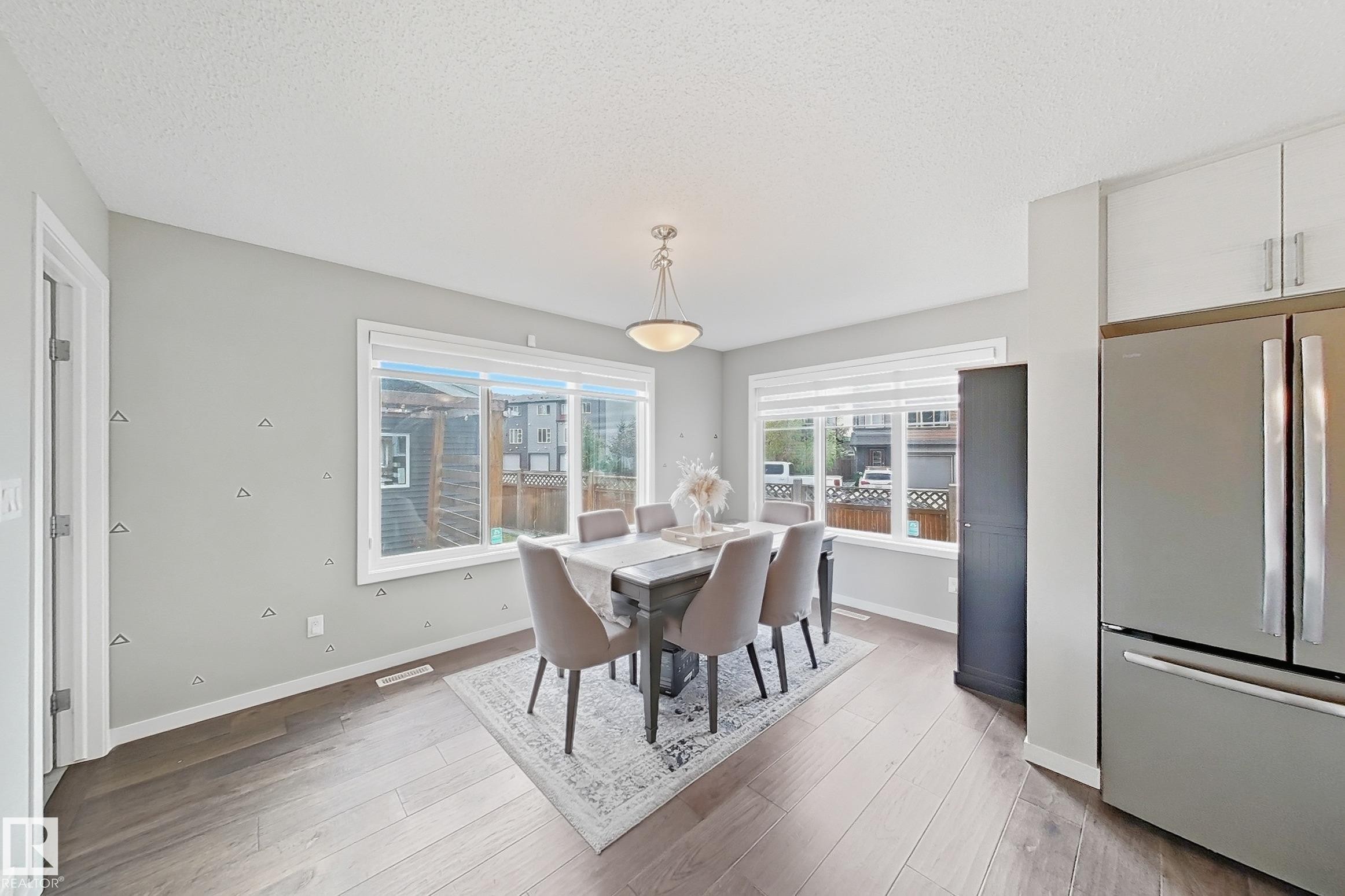 Dining room with light wood-style flooring and a textured ceiling - 4303 Prowse Link, Edmonton, AB - Indoor Photo Showing Dining Room