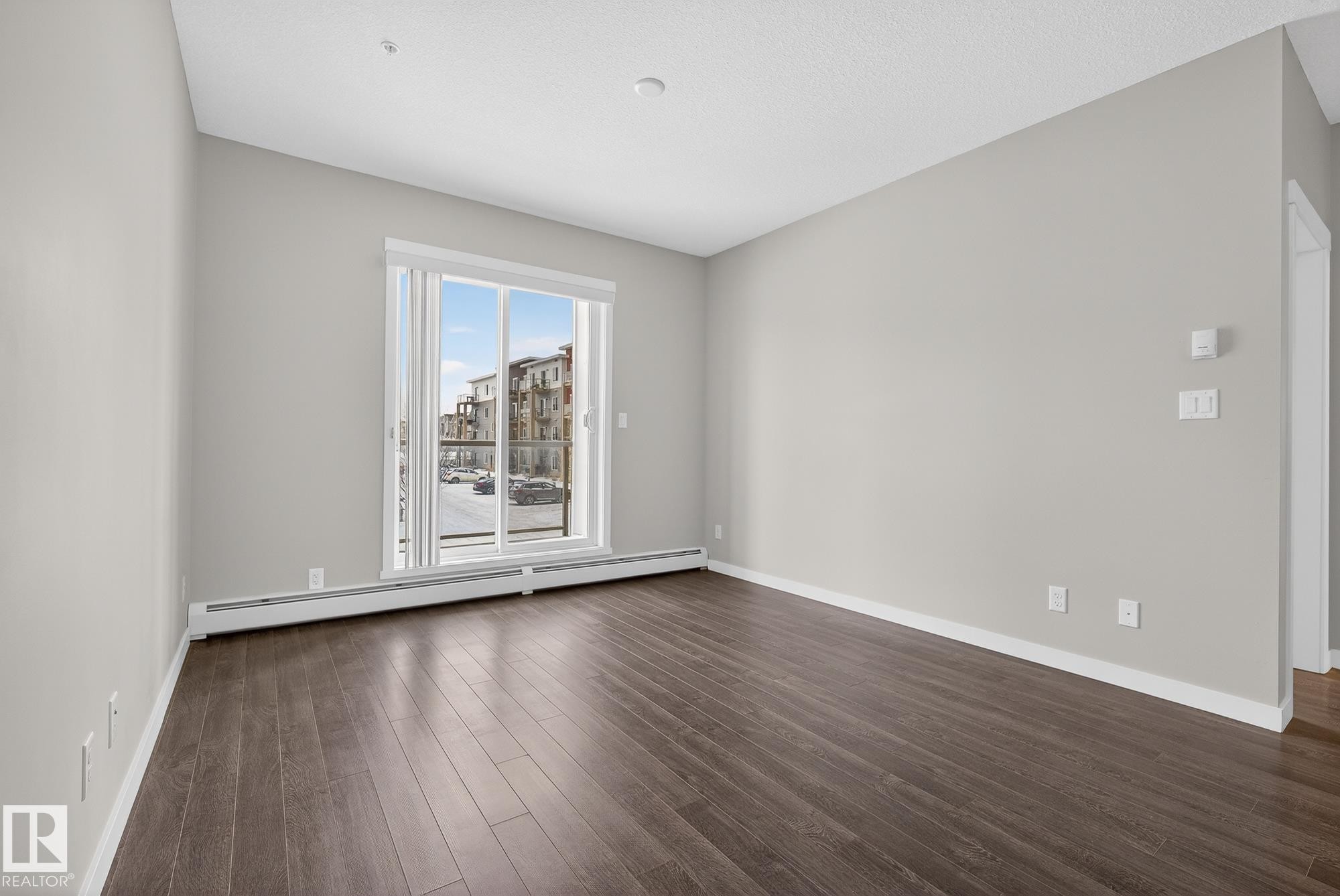 Spare room with a baseboard radiator and dark wood-style floors - 206 812 Welsh Drive, Edmonton, AB - Indoor Photo Showing Other Room