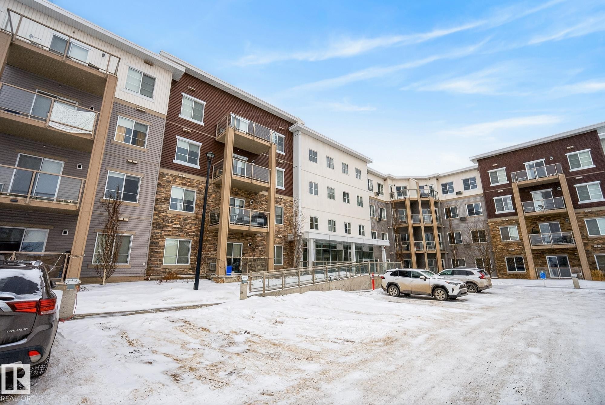 Snow covered property featuring a view of apartment building / complex and uncovered parking - 206 812 Welsh Drive, Edmonton, AB - Outdoor With Balcony With Facade