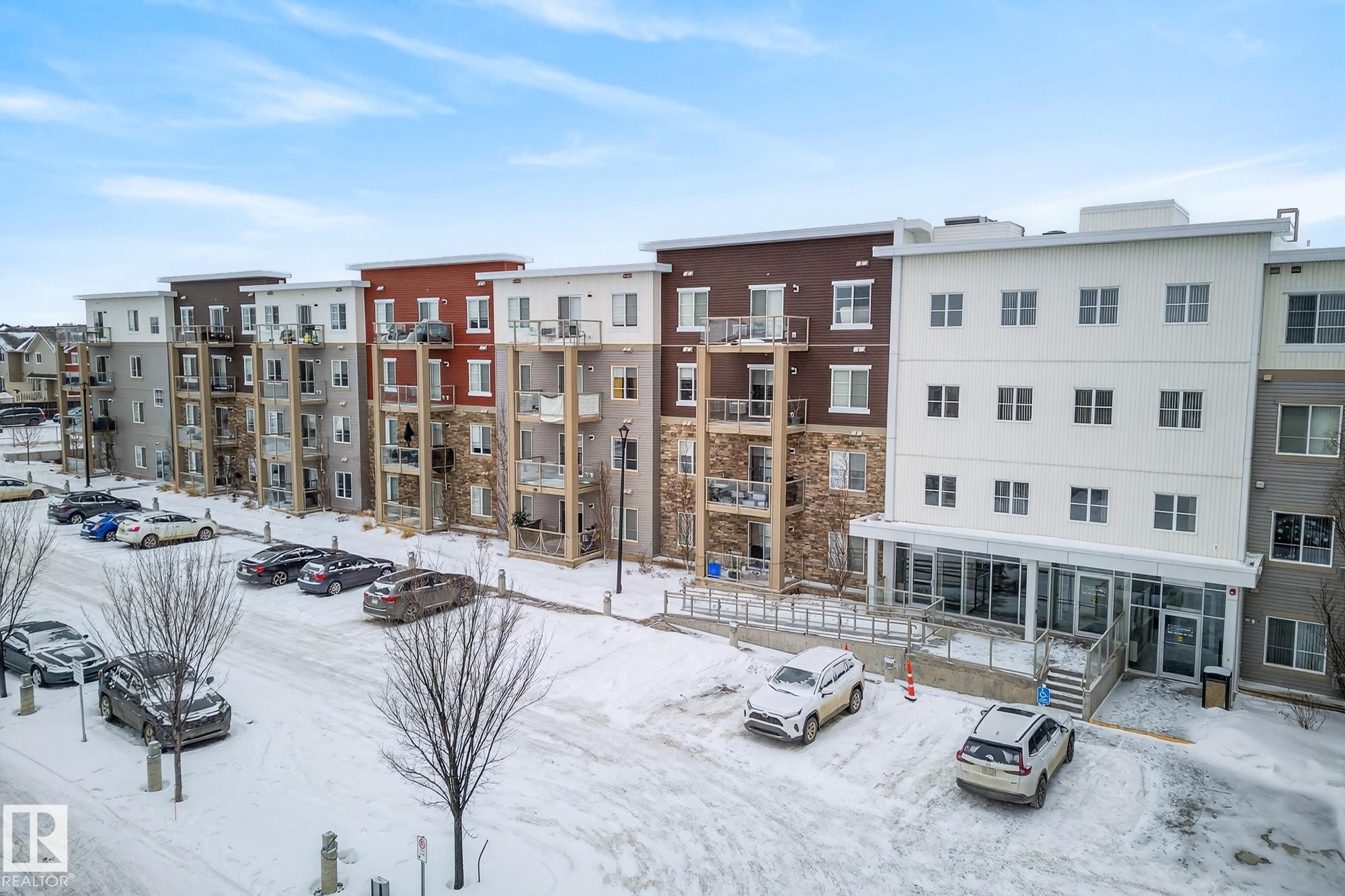 Snow covered property with a view of apartment building / complex and uncovered parking - 206 812 Welsh Drive, Edmonton, AB - Outdoor With Balcony