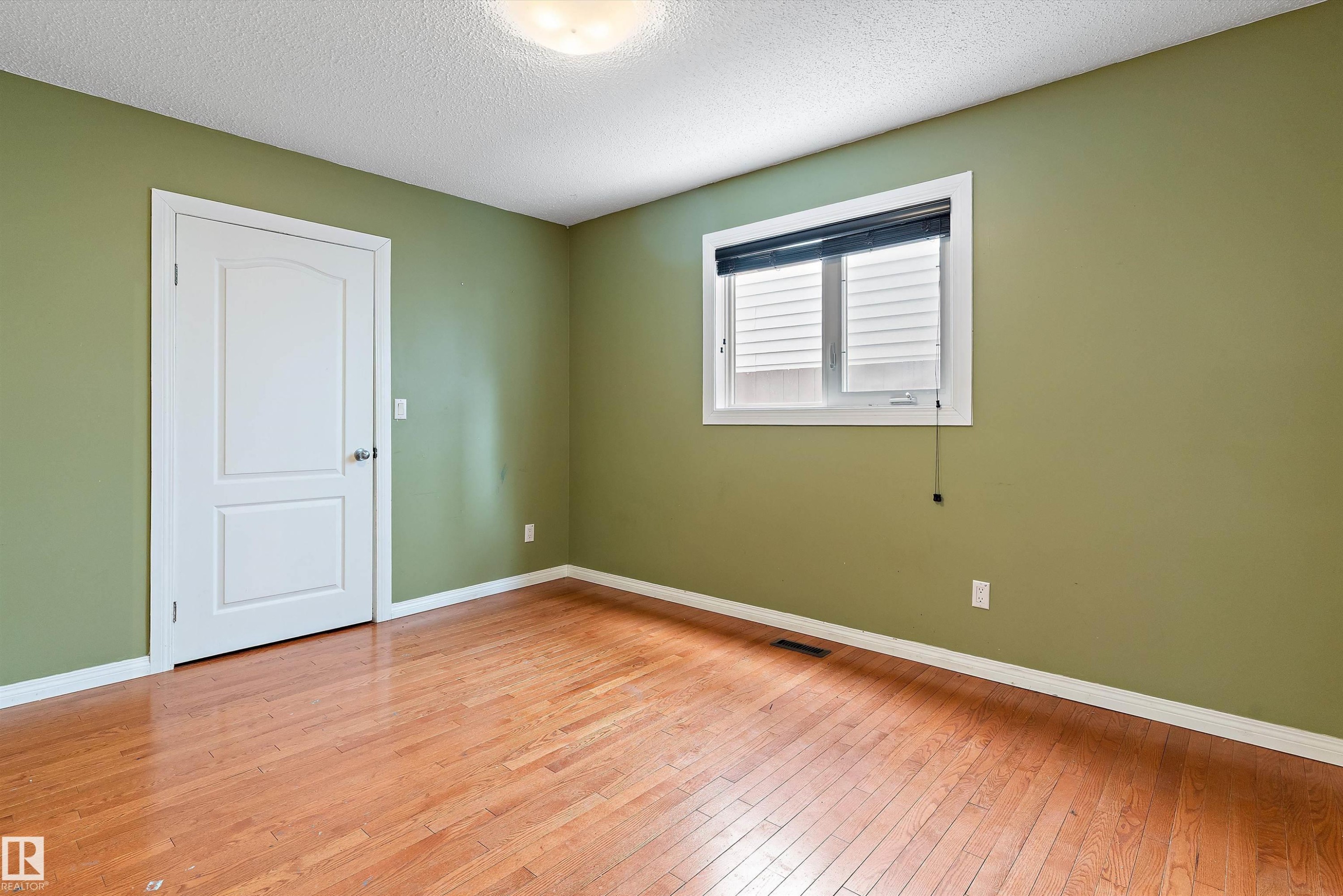 Spare room featuring a textured ceiling and light wood finished floors - 115 Walker Road, Edmonton, AB - Indoor Photo Showing Other Room