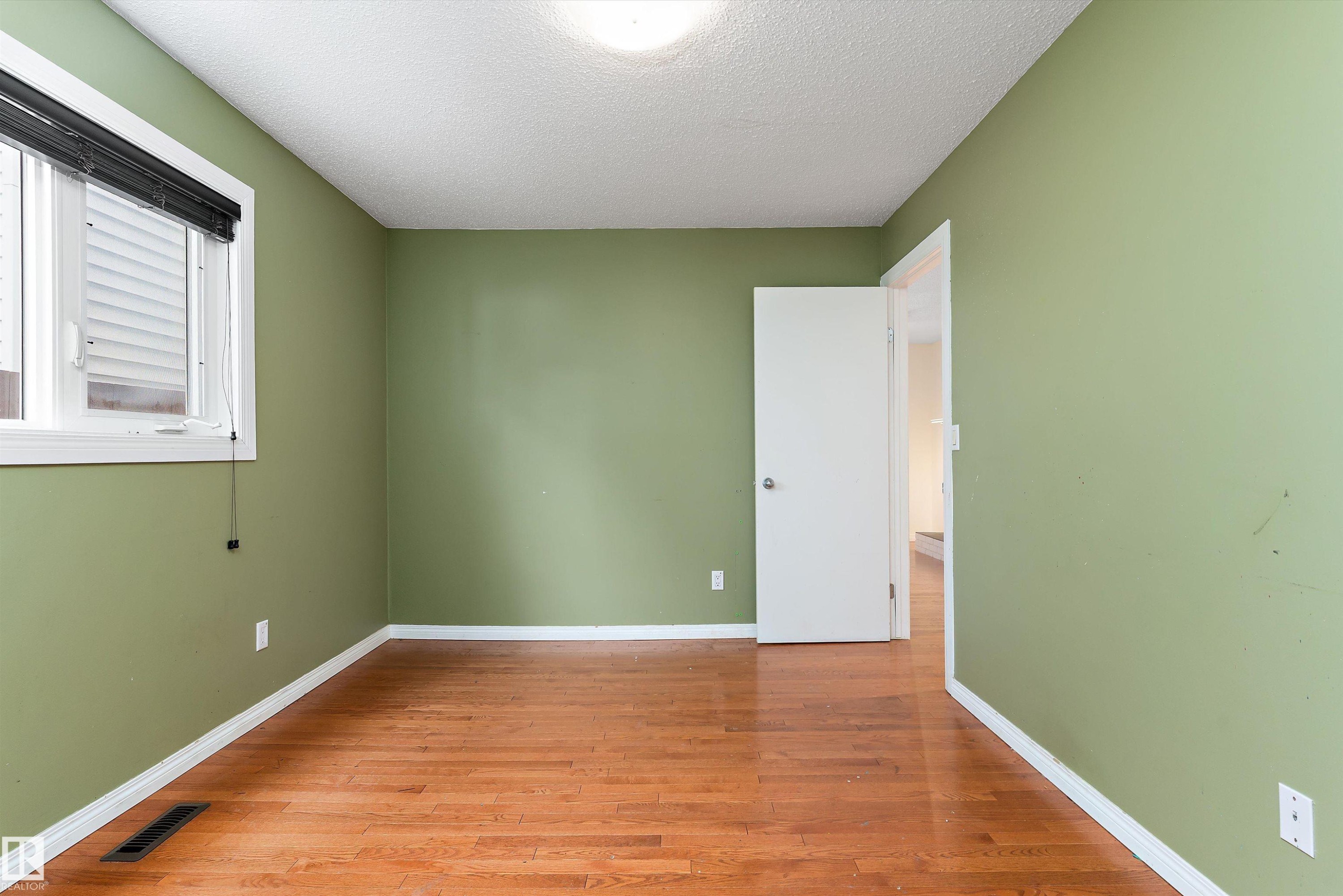 Empty room featuring light wood-style floors and a textured ceiling - 115 Walker Road, Edmonton, AB - Indoor Photo Showing Other Room