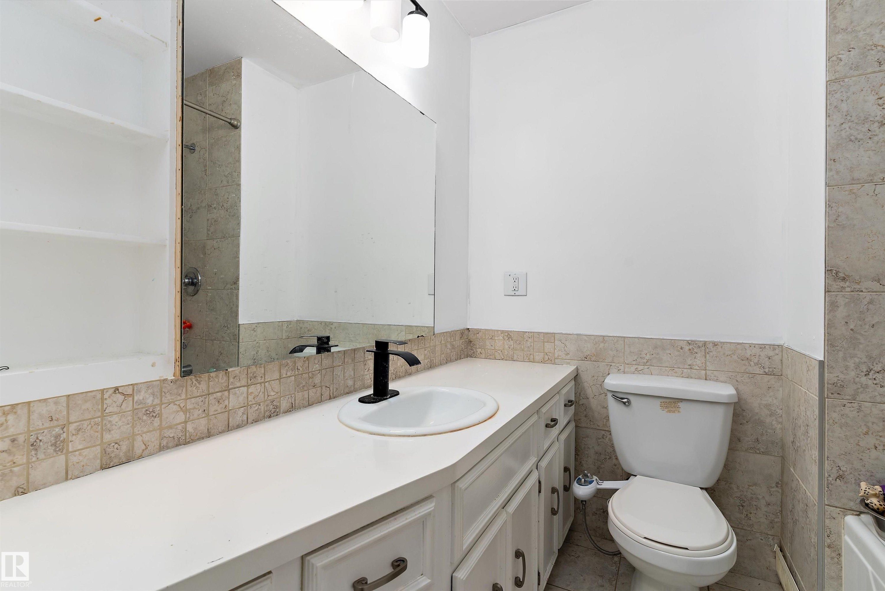 Bathroom with vanity, tile walls, and shower / bath combination - 115 Walker Road, Edmonton, AB - Indoor Photo Showing Bathroom