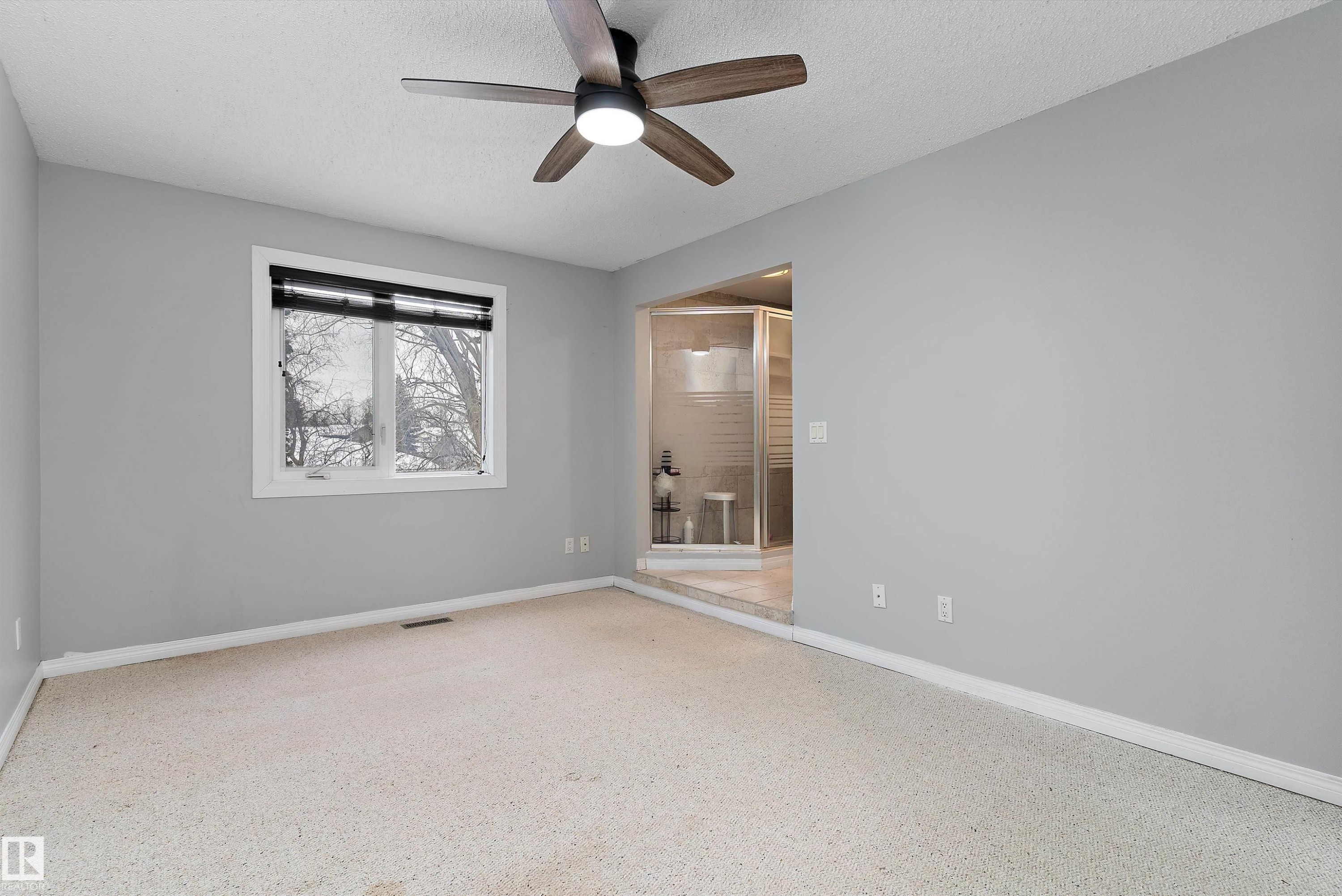 Unfurnished room featuring ceiling fan, a textured ceiling, and dark speckled floor - 115 Walker Road, Edmonton, AB - Indoor Photo Showing Other Room