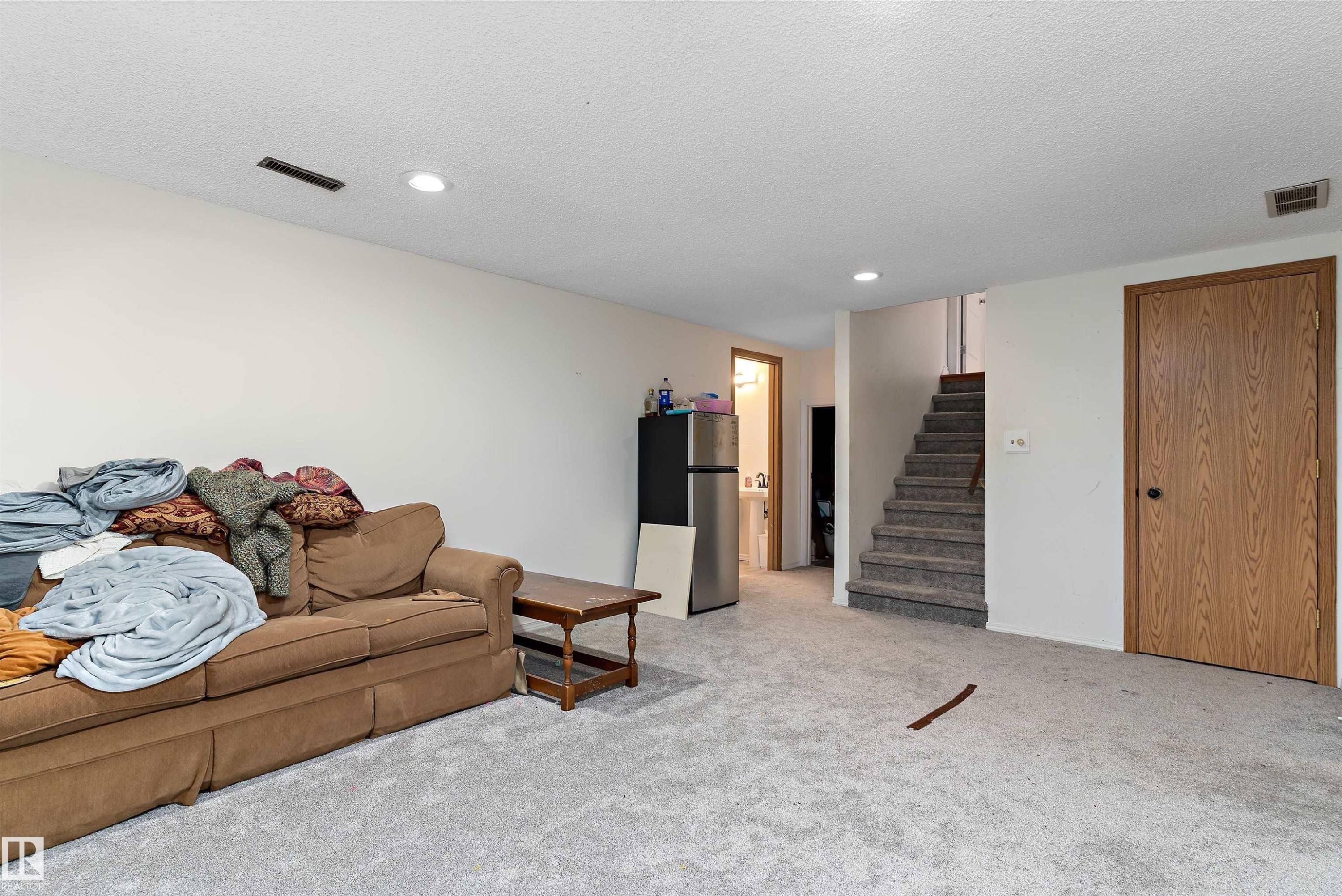 Living room featuring light colored carpet, recessed lighting, and a textured ceiling - 115 Walker Road, Edmonton, AB - Indoor