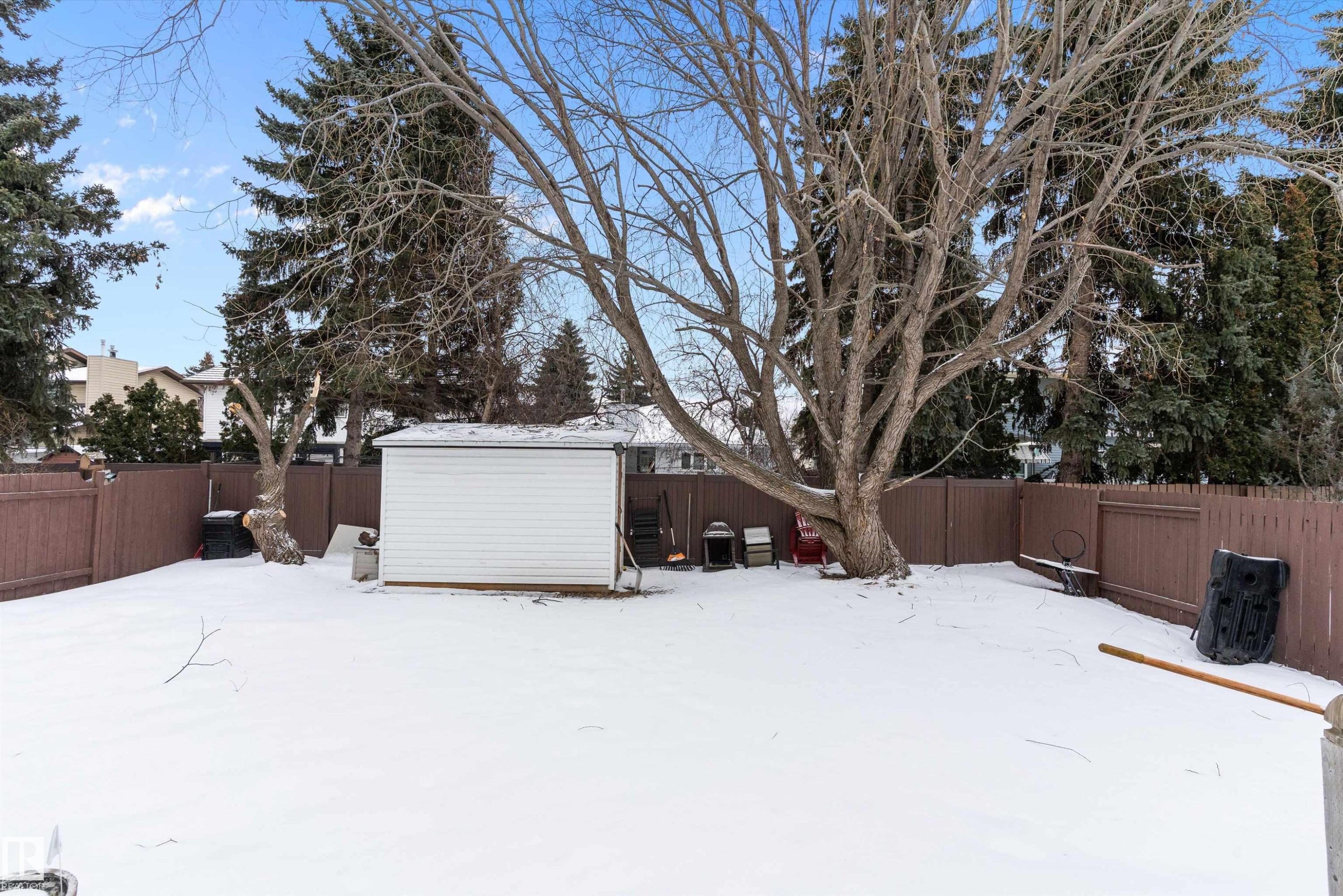 Snowy yard featuring a fenced backyard and a shed - 115 Walker Road, Edmonton, AB - Outdoor