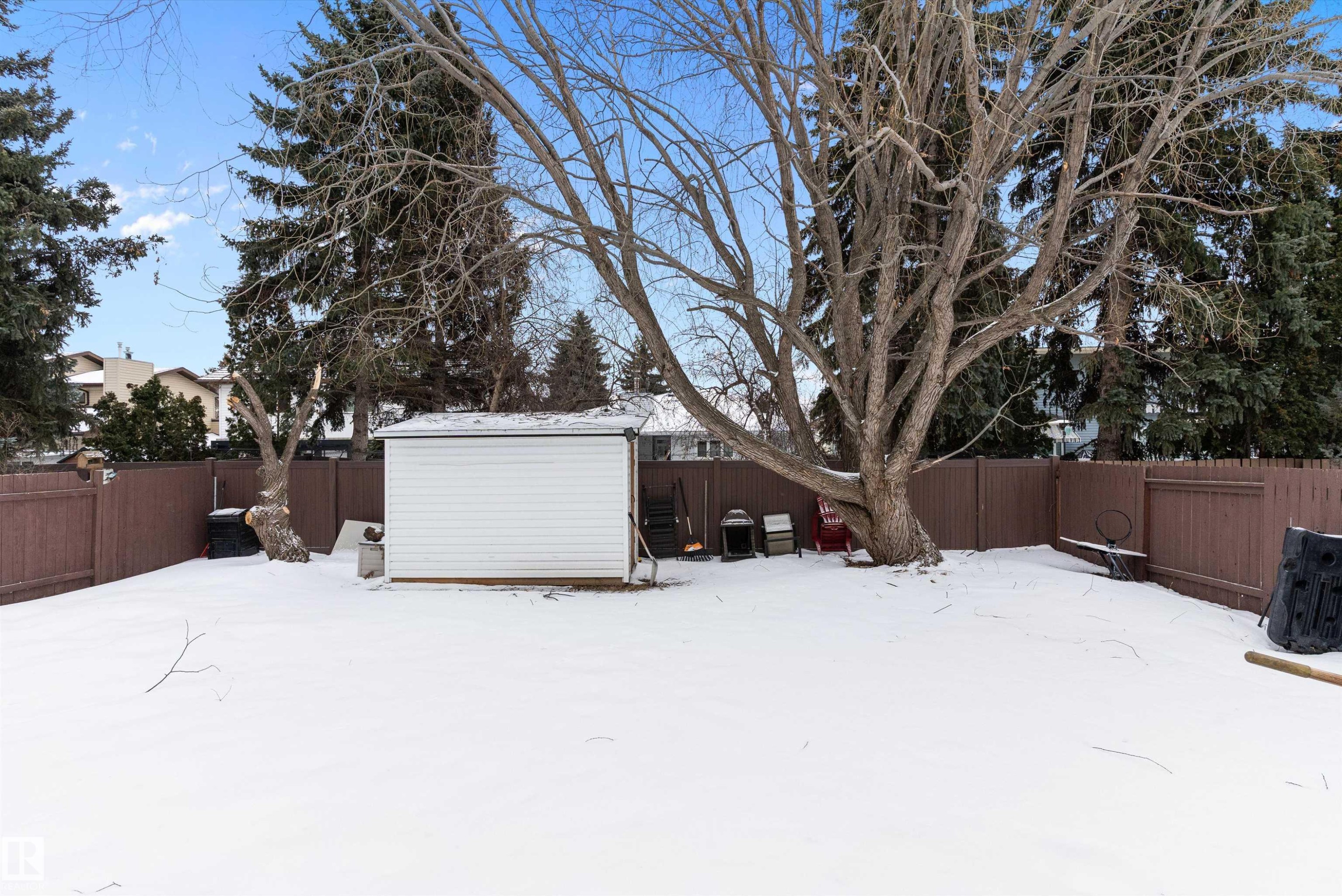 Yard covered in snow featuring a fenced backyard and a storage unit - 115 Walker Road, Edmonton, AB - Outdoor