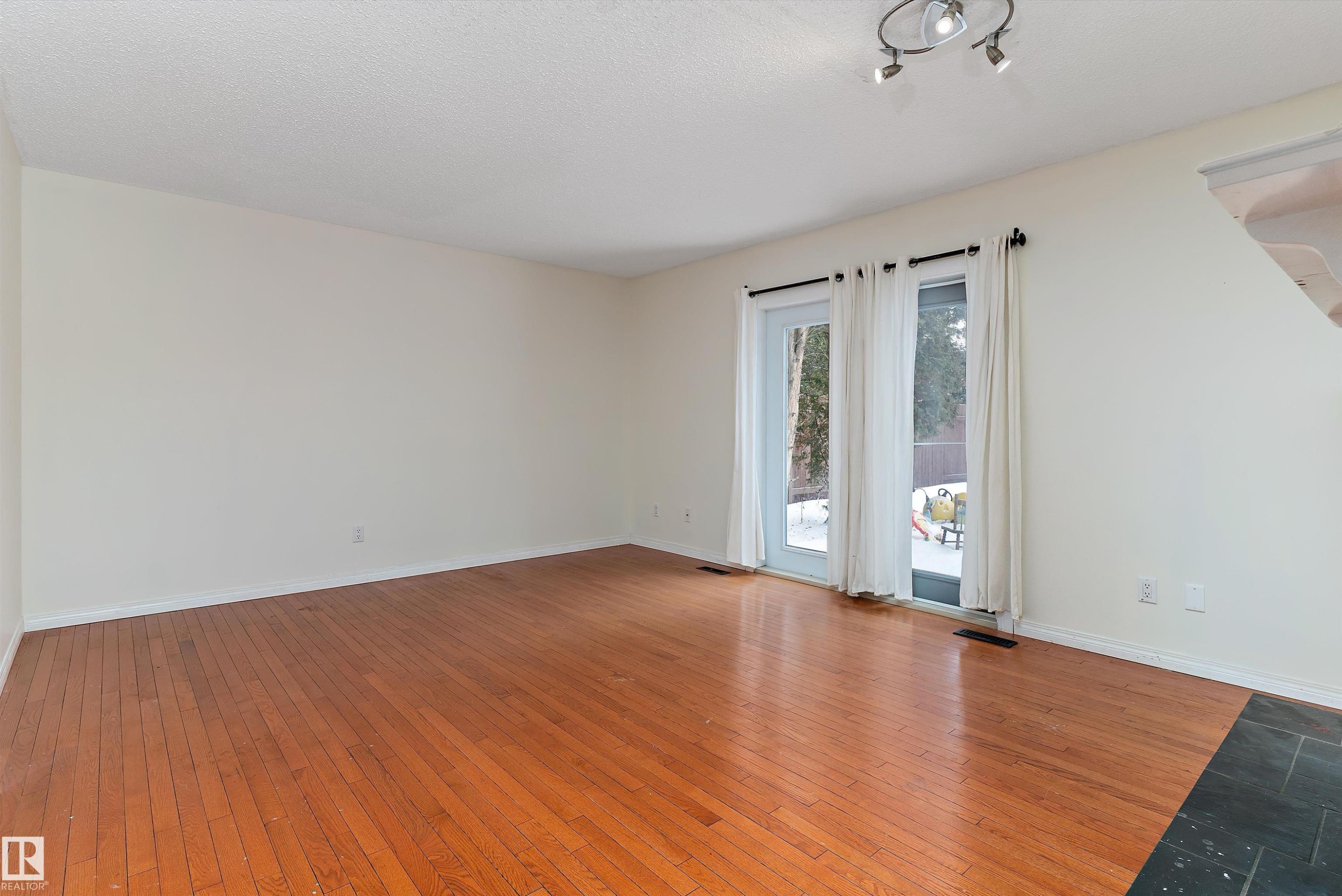 Unfurnished room featuring hardwood / wood-style flooring and a textured ceiling - 115 Walker Road, Edmonton, AB - Indoor Photo Showing Other Room