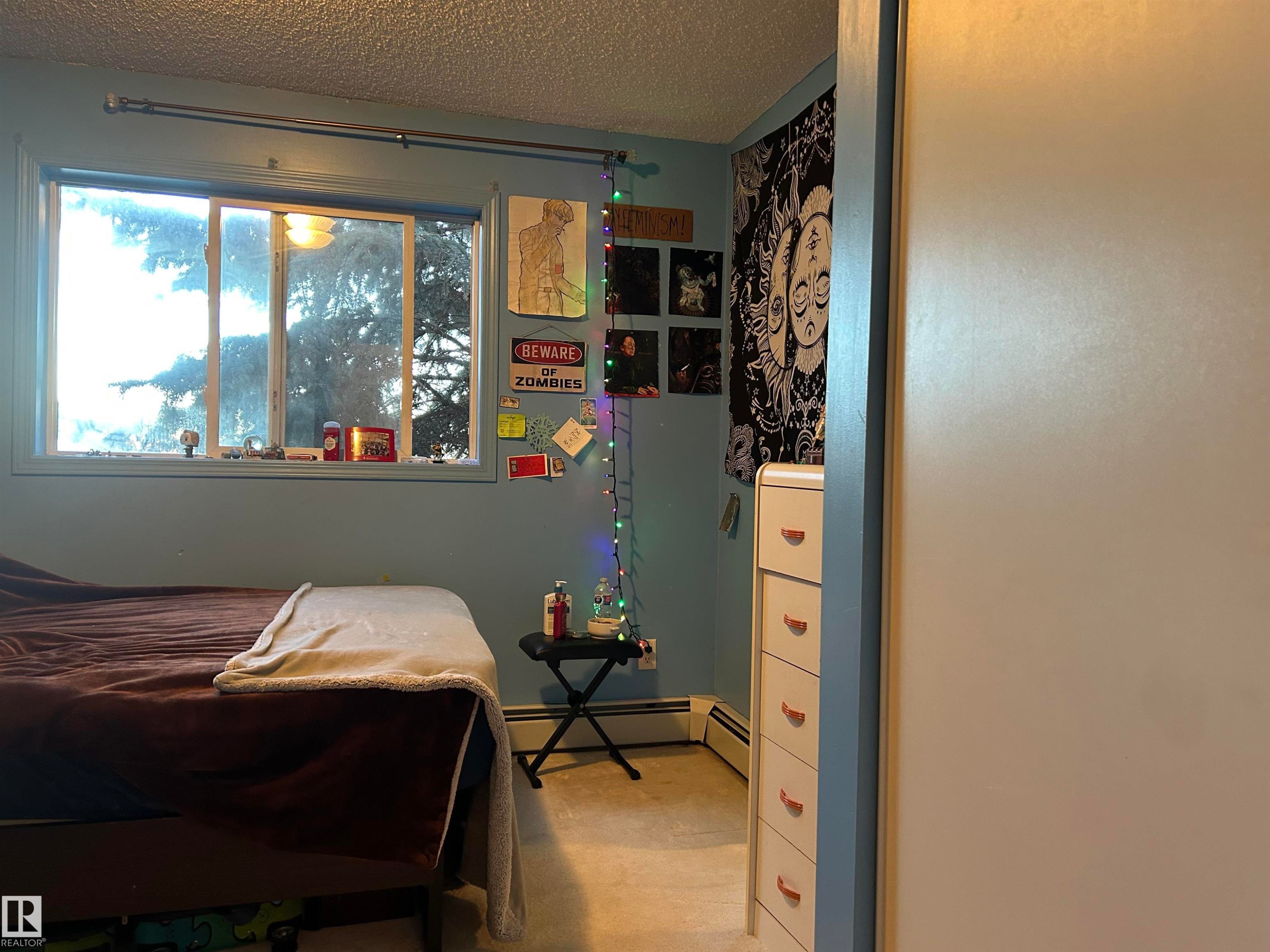 Bedroom featuring a textured ceiling and a baseboard radiator - 310 2430 Guardian Road, Edmonton, AB - Indoor Photo Showing Other Room
