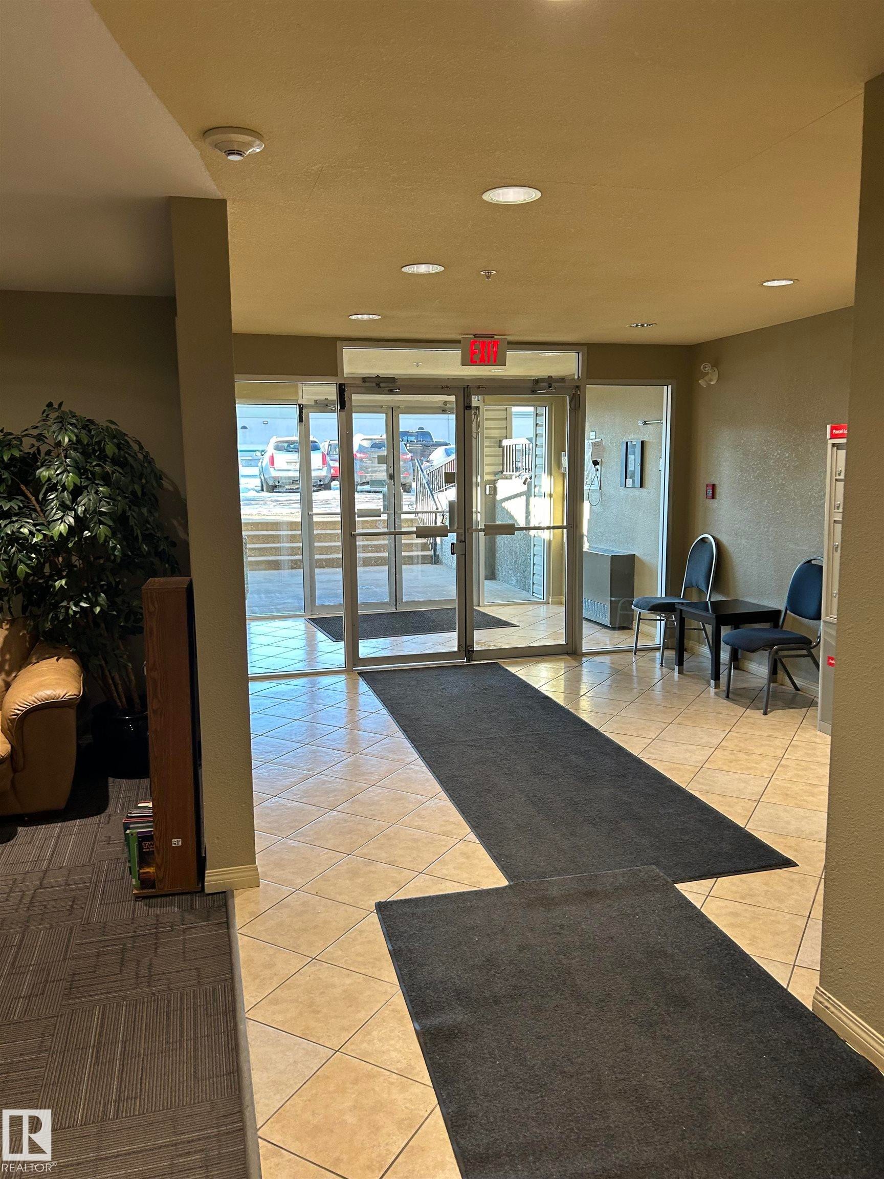 Community lobby featuring a textured wall and recessed lighting - 310 2430 Guardian Road, Edmonton, AB - Indoor Photo Showing Other Room