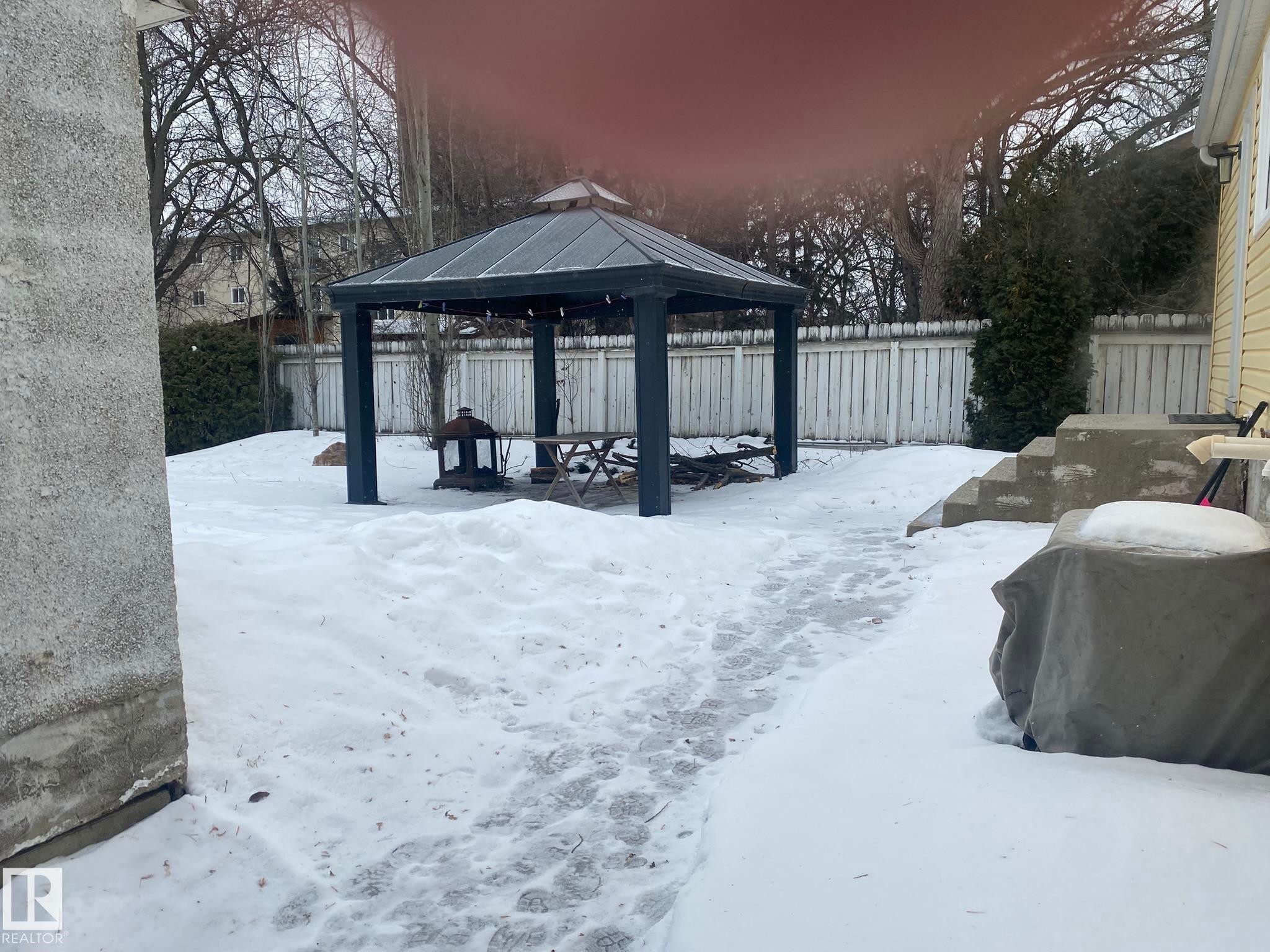 Snowy yard with a gazebo, a patio, and a fenced backyard - 10945 54 Avenue, Edmonton, AB - Outdoor