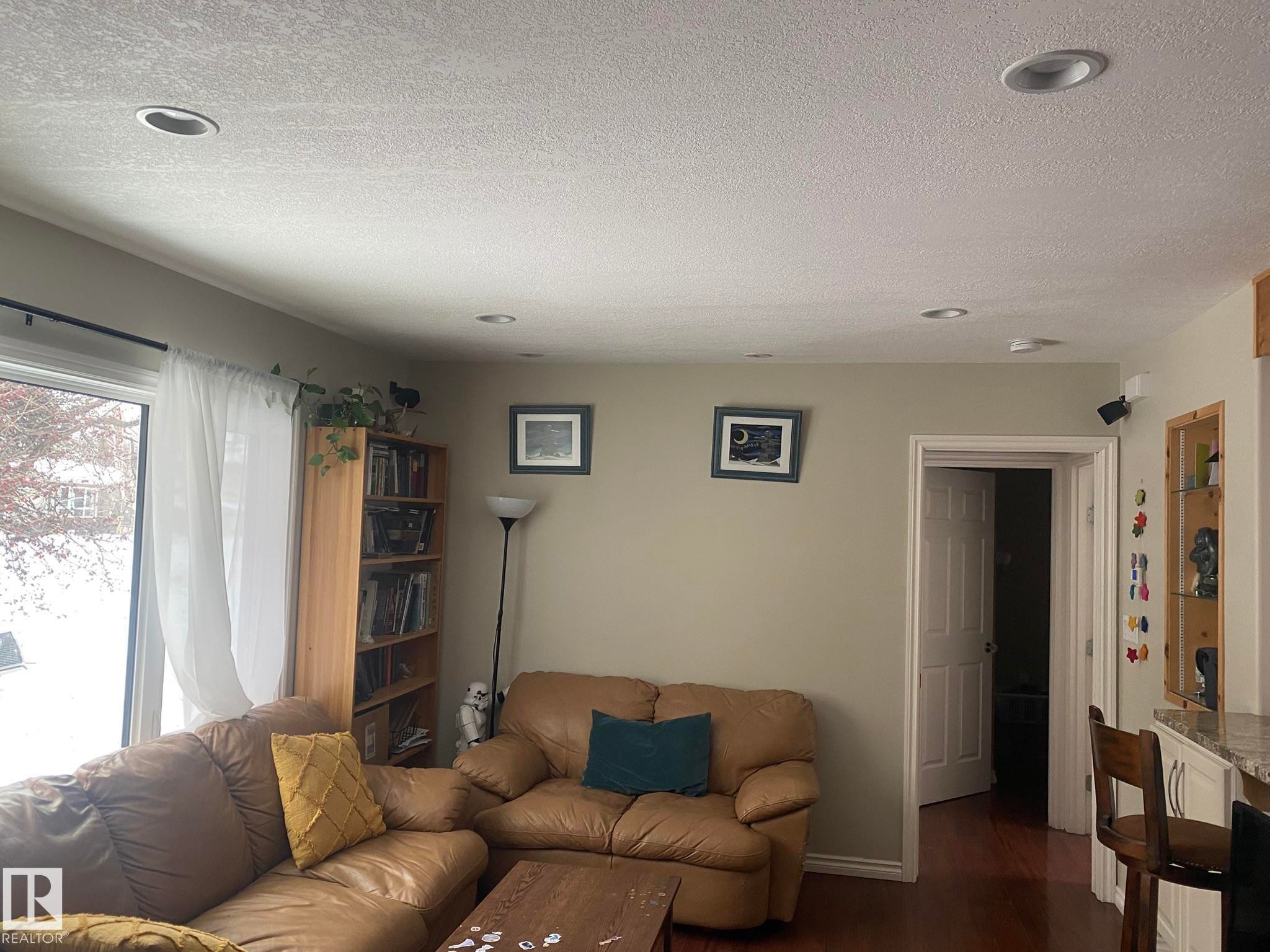 Living area featuring dark wood-style floors, recessed lighting, and a textured ceiling - 10945 54 Avenue, Edmonton, AB - Indoor Photo Showing Living Room